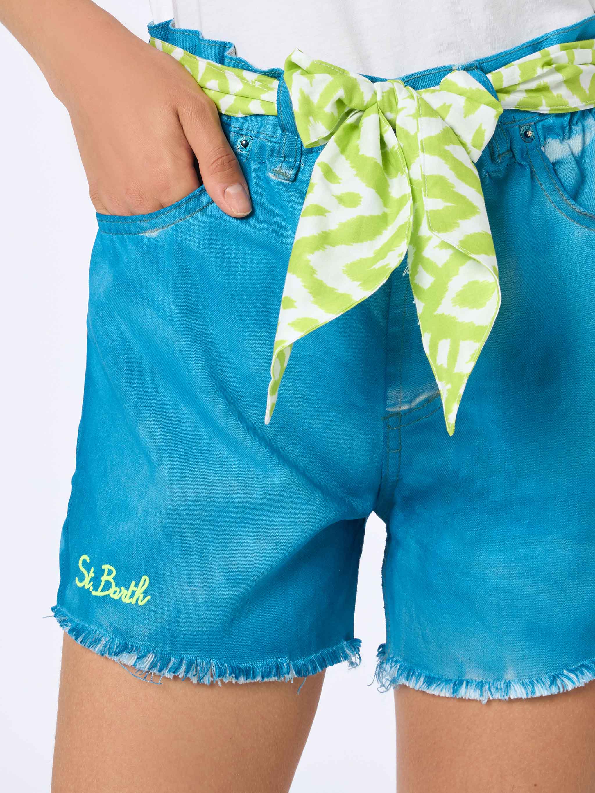 Shorts jeans turquesa reciclados com bordado, usados por uma mulher do Arizona.