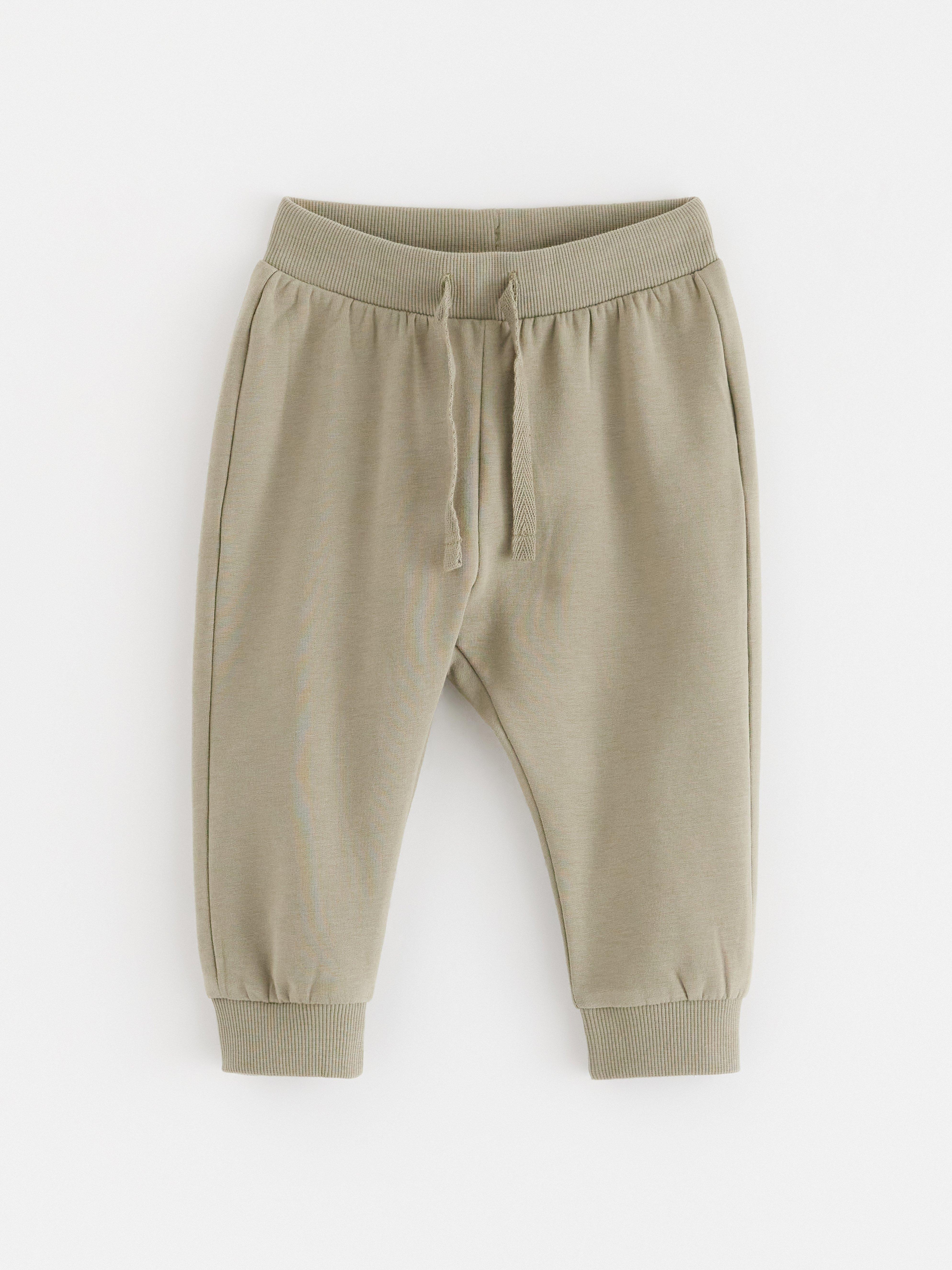 Pantalones deportivos con interior cepillado, color caqui claro empolvado.