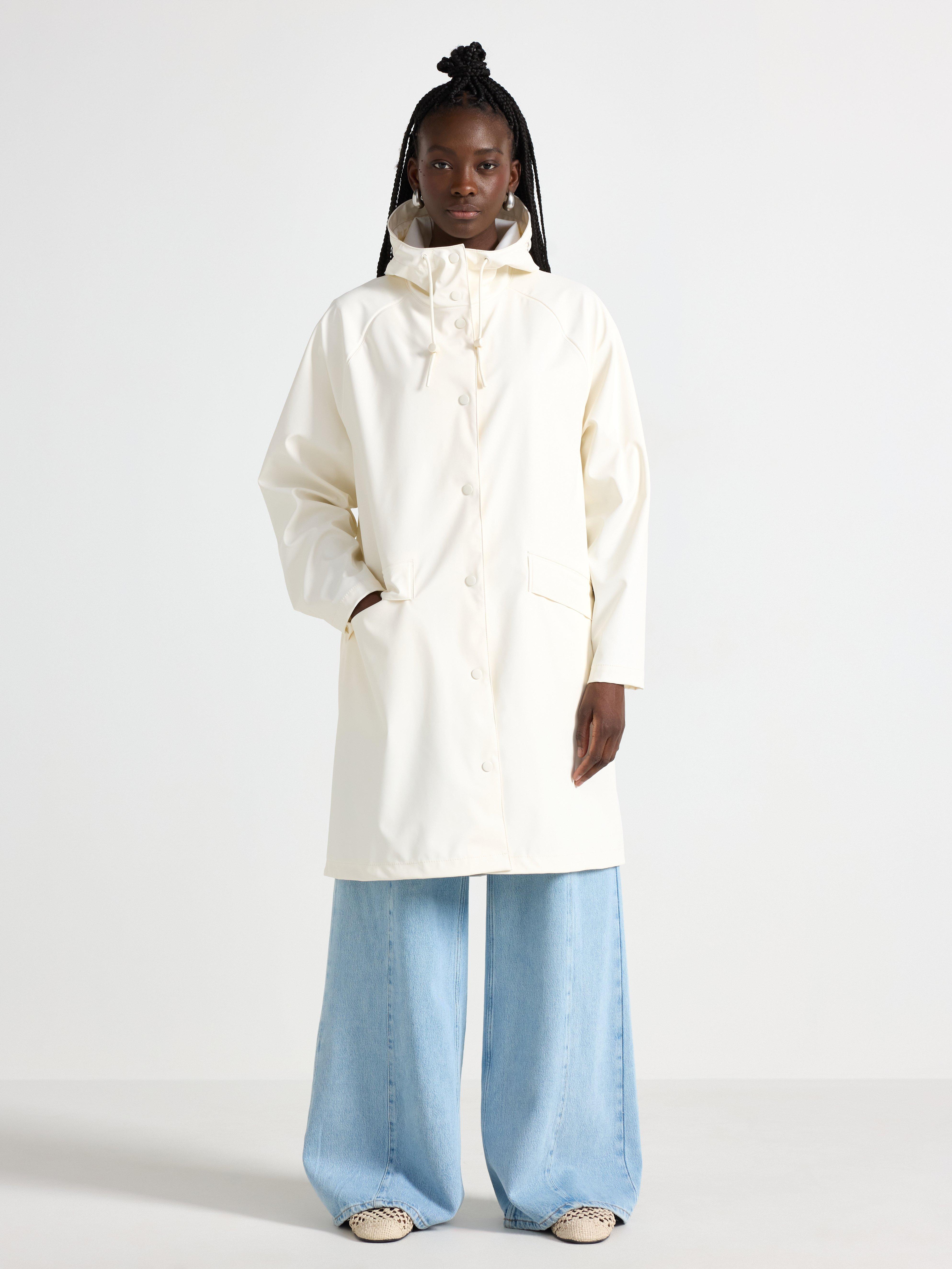 Chaqueta impermeable con capucha color blanco roto.