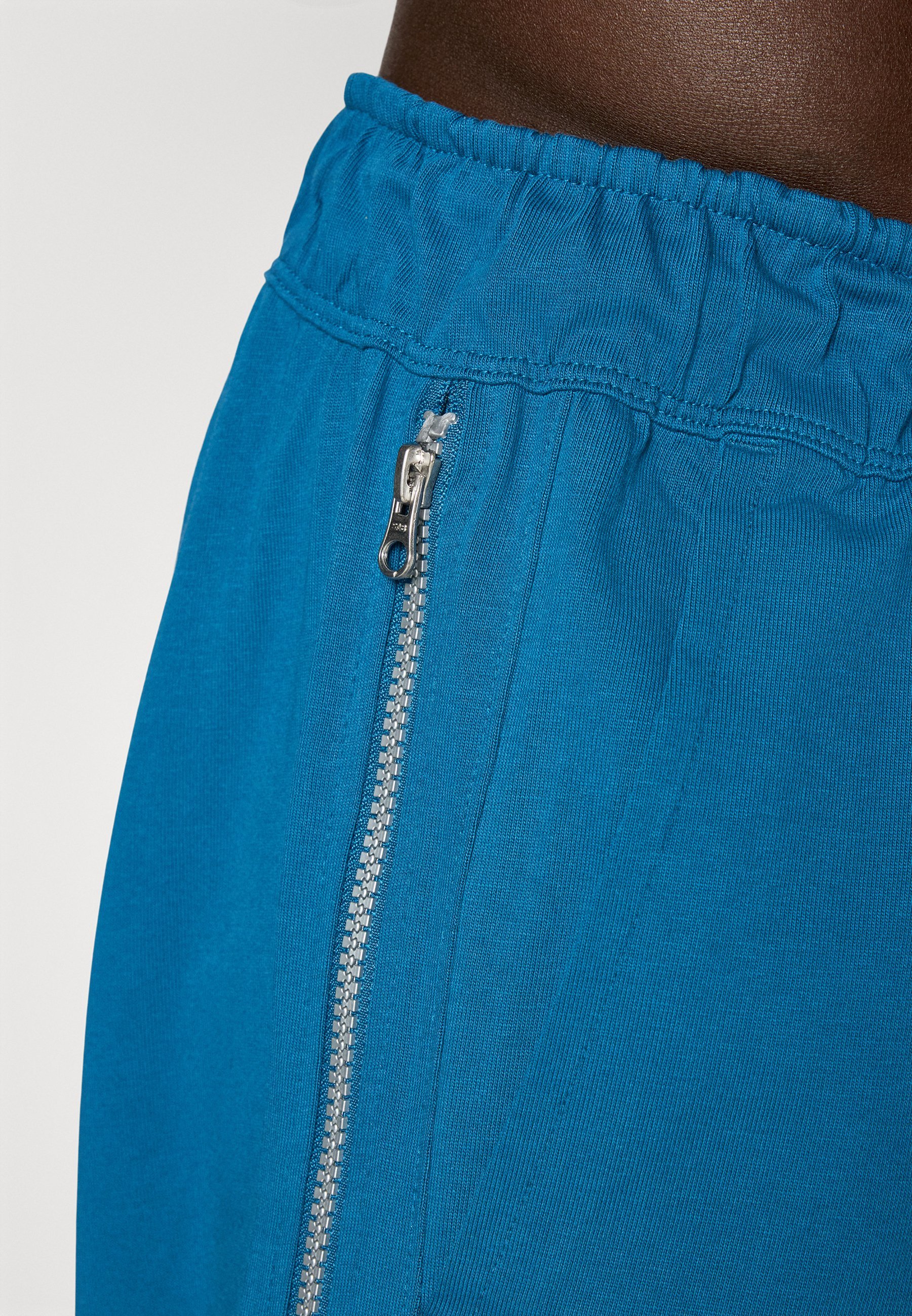 Spodnie dresowe Nike Performance PANT NAOS – kolor blue force/blade ivory