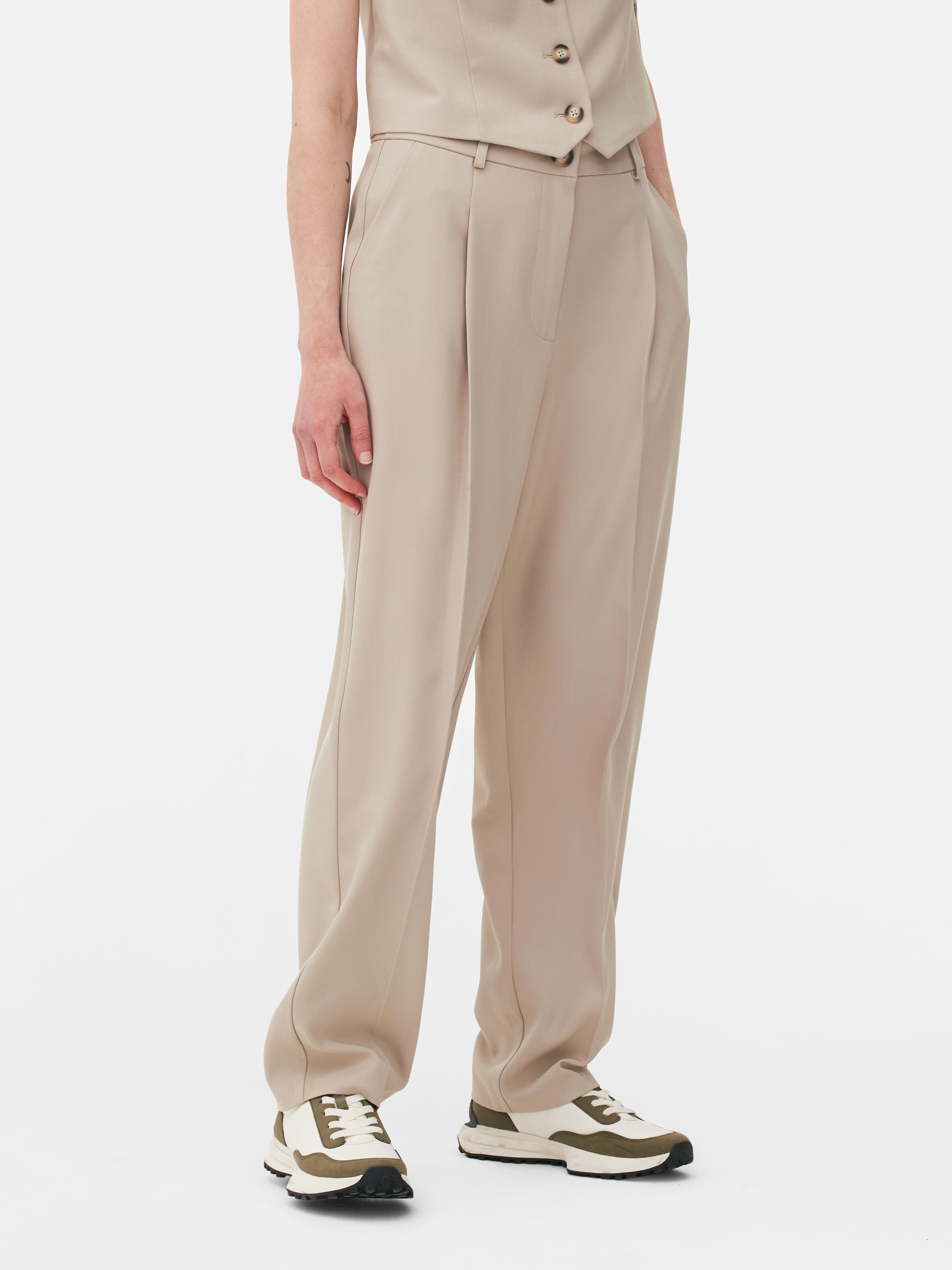 Passende Hose mit geradem Bein. Eine minimalistische Hose mit Bundfalten, geradem Schnitt und neutraler Farbe.