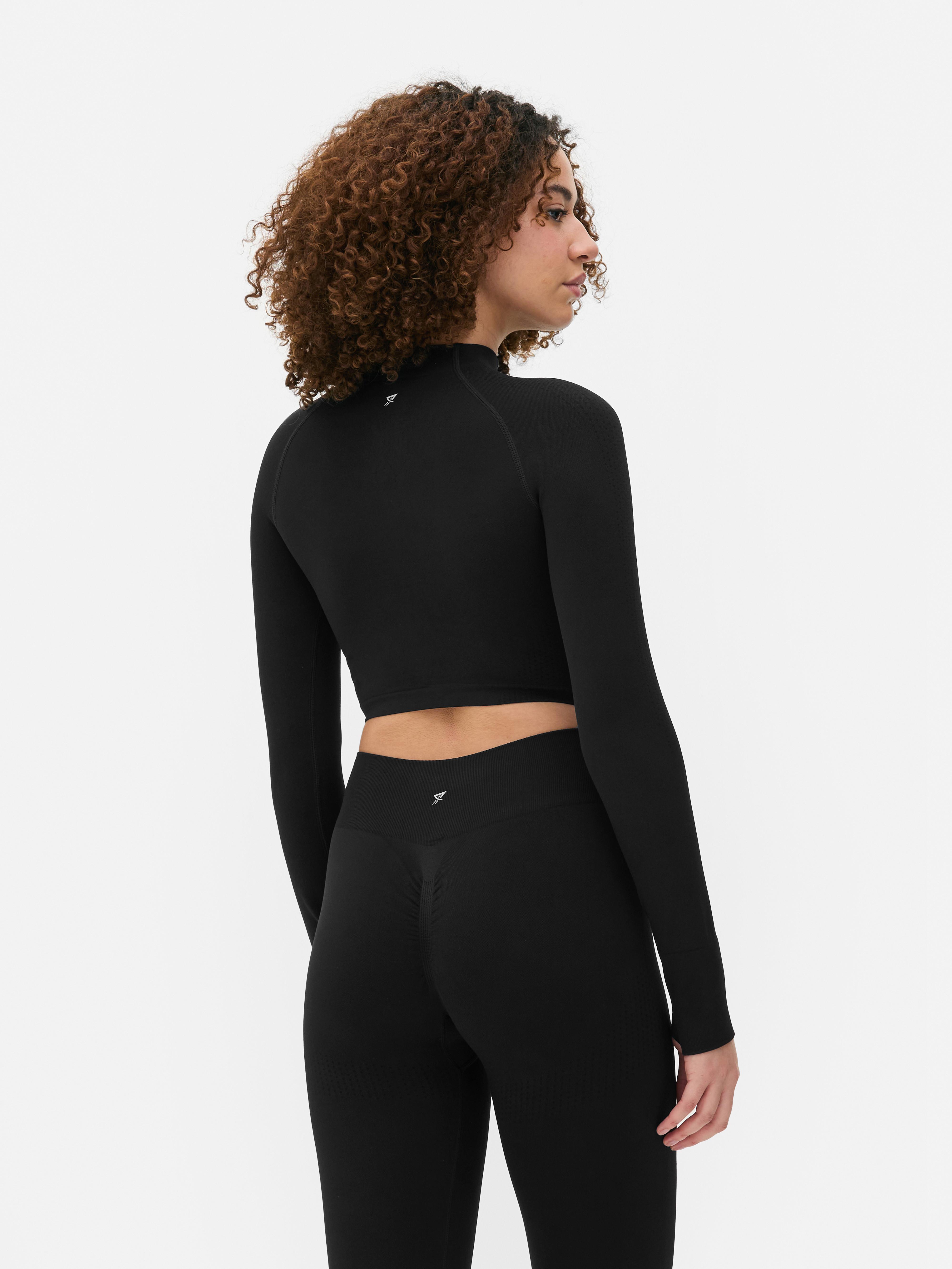 Top sport modelator cu mâneci lungi, fără cusături. Acest top sport scurt, cu fermoar pe jumătate și design fără cusături, este funcțional și elegant.