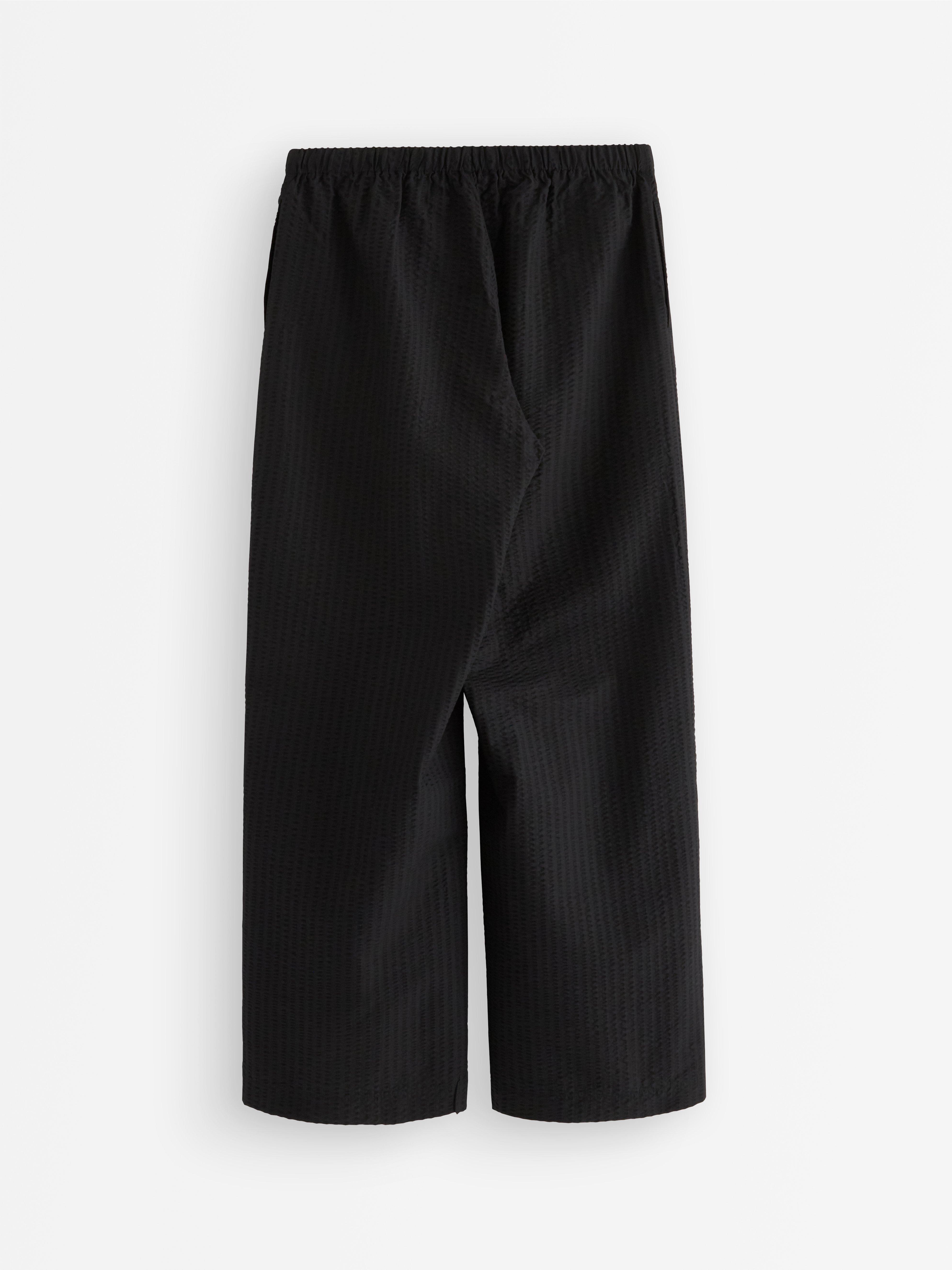 Pantalones rectos acampanados de color negro