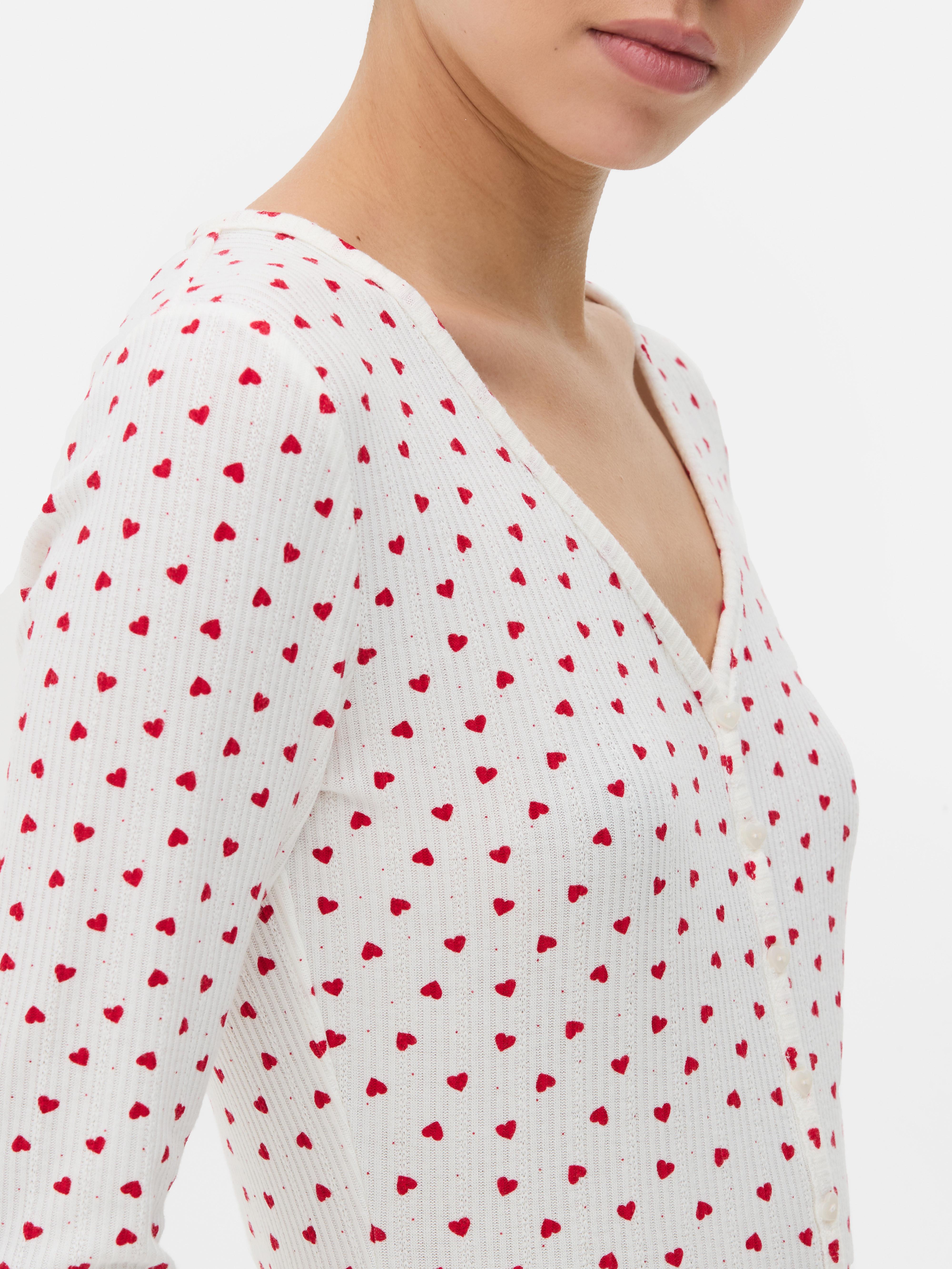 Salopetă de pijama cu model cu inimă. O salopetă de pijama confecționată din material moale cu nervuri, cu tiv festonat și model.