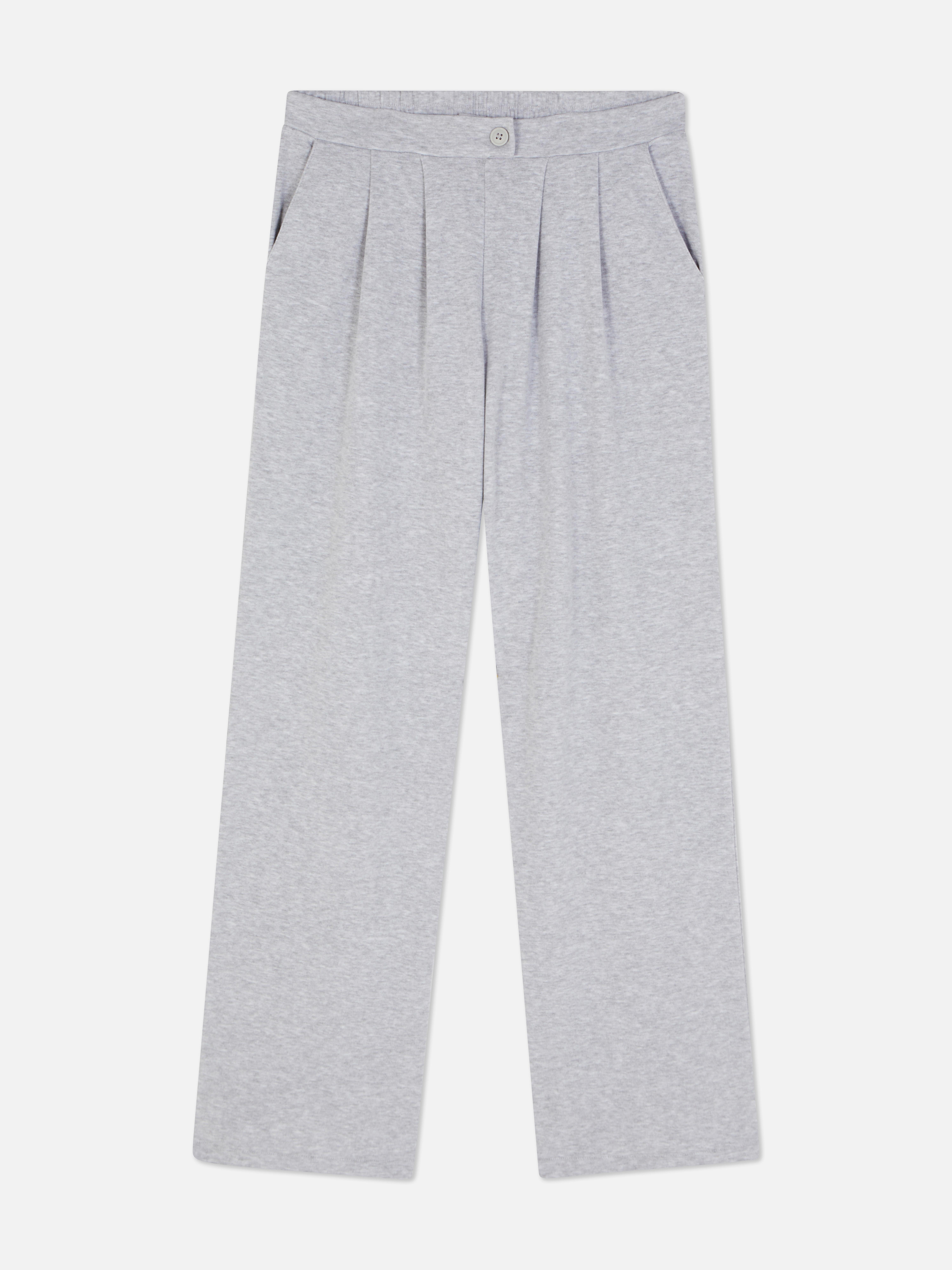 Pantaloni de trening din jerseu mulați. Acești pantaloni de trening au o fentă vizibilă cu nasturi și o siluetă elegantă.