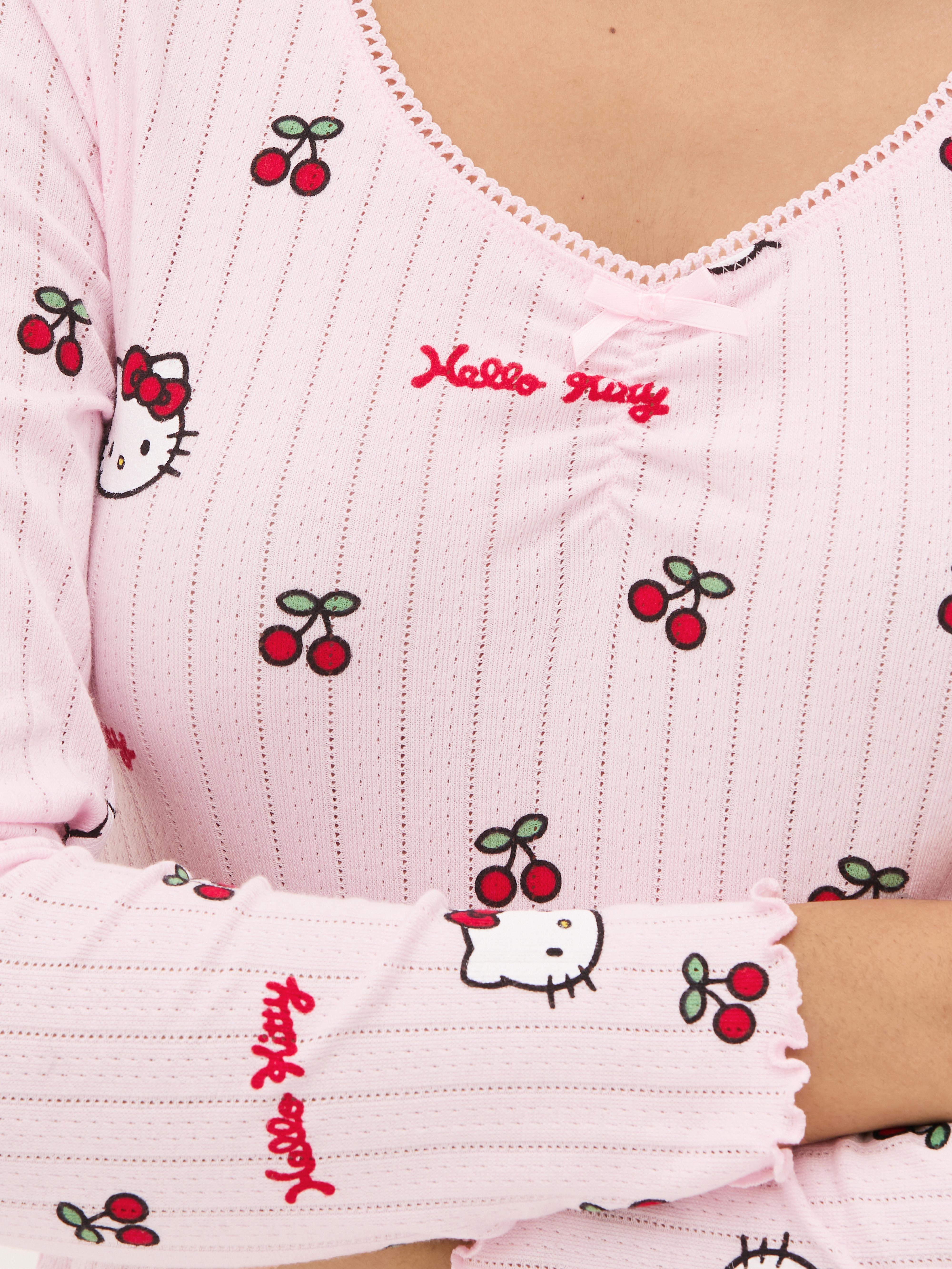 Top de pijama cu mânecă lungă și imprimeu Hello Kitty ajurat Un top de pijama Hello Kitty cu mâneci lungi, ajurat, garnitură picot și tiv festonat