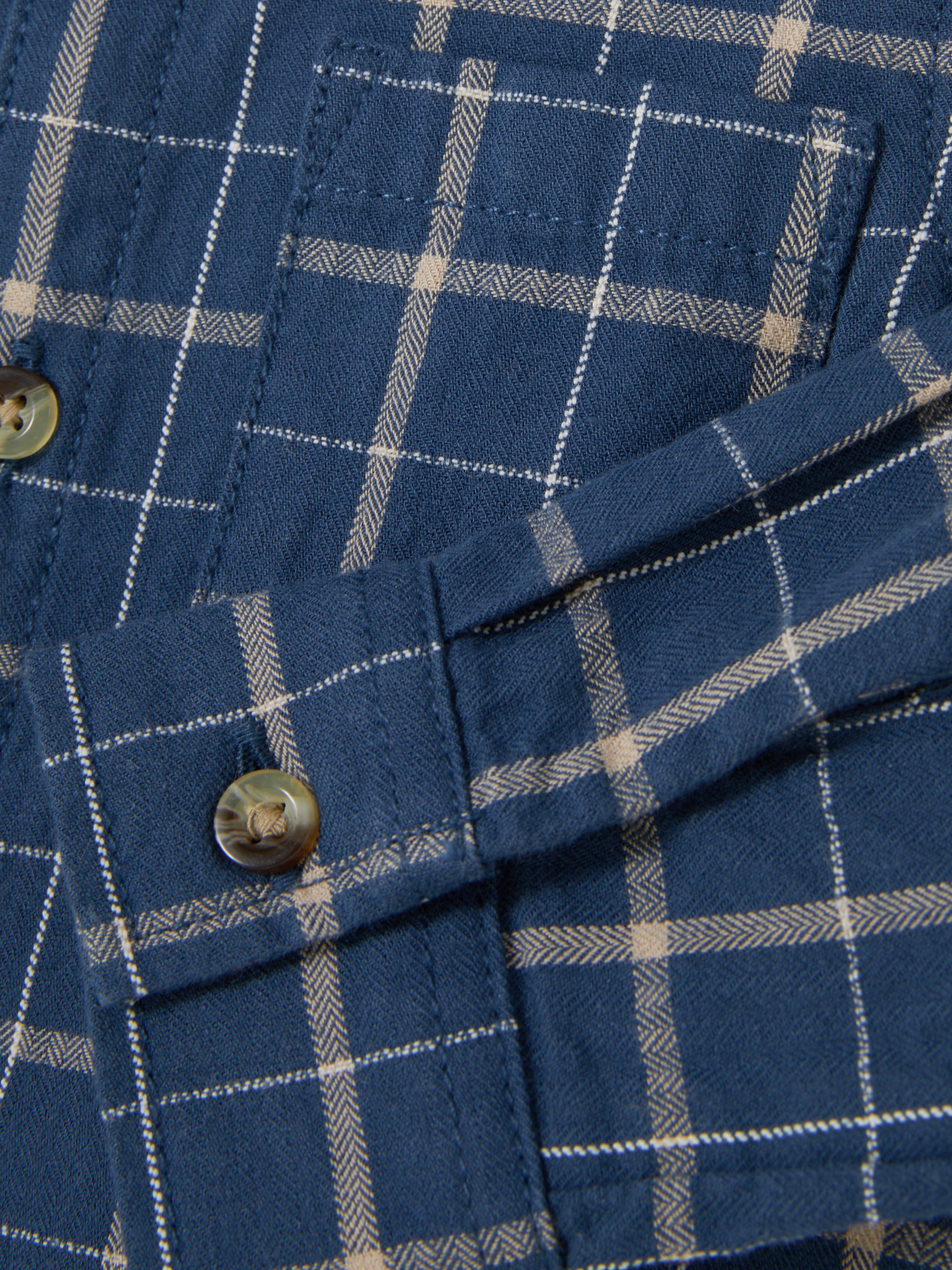 Cămașă în carouri cu nasturi O cămașă în carouri cu guler, nasturi, mâneci lungi și buzunar aplicat la piept
