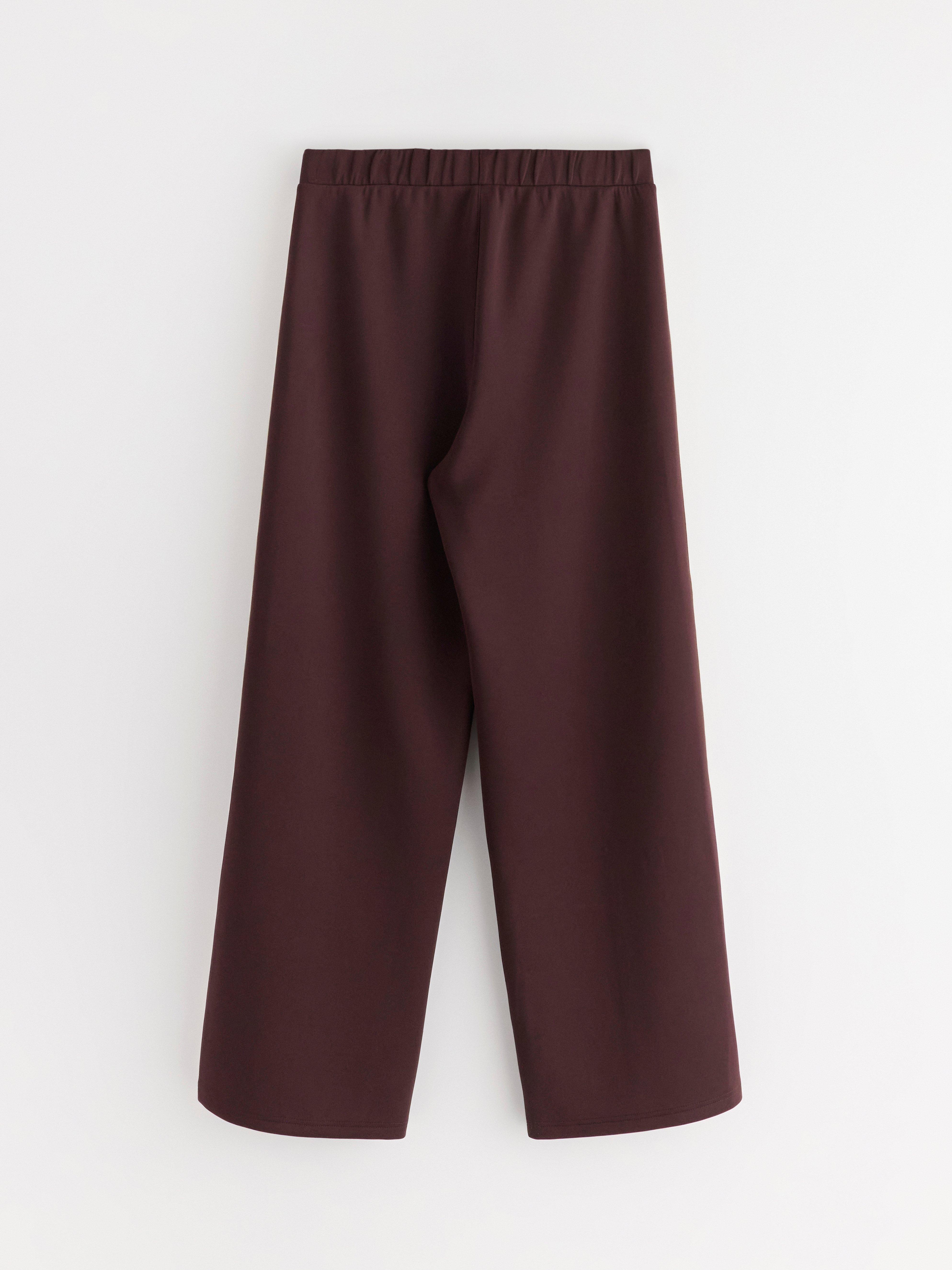Pantalones de pierna ancha en punto color rojo oscuro empolvado.