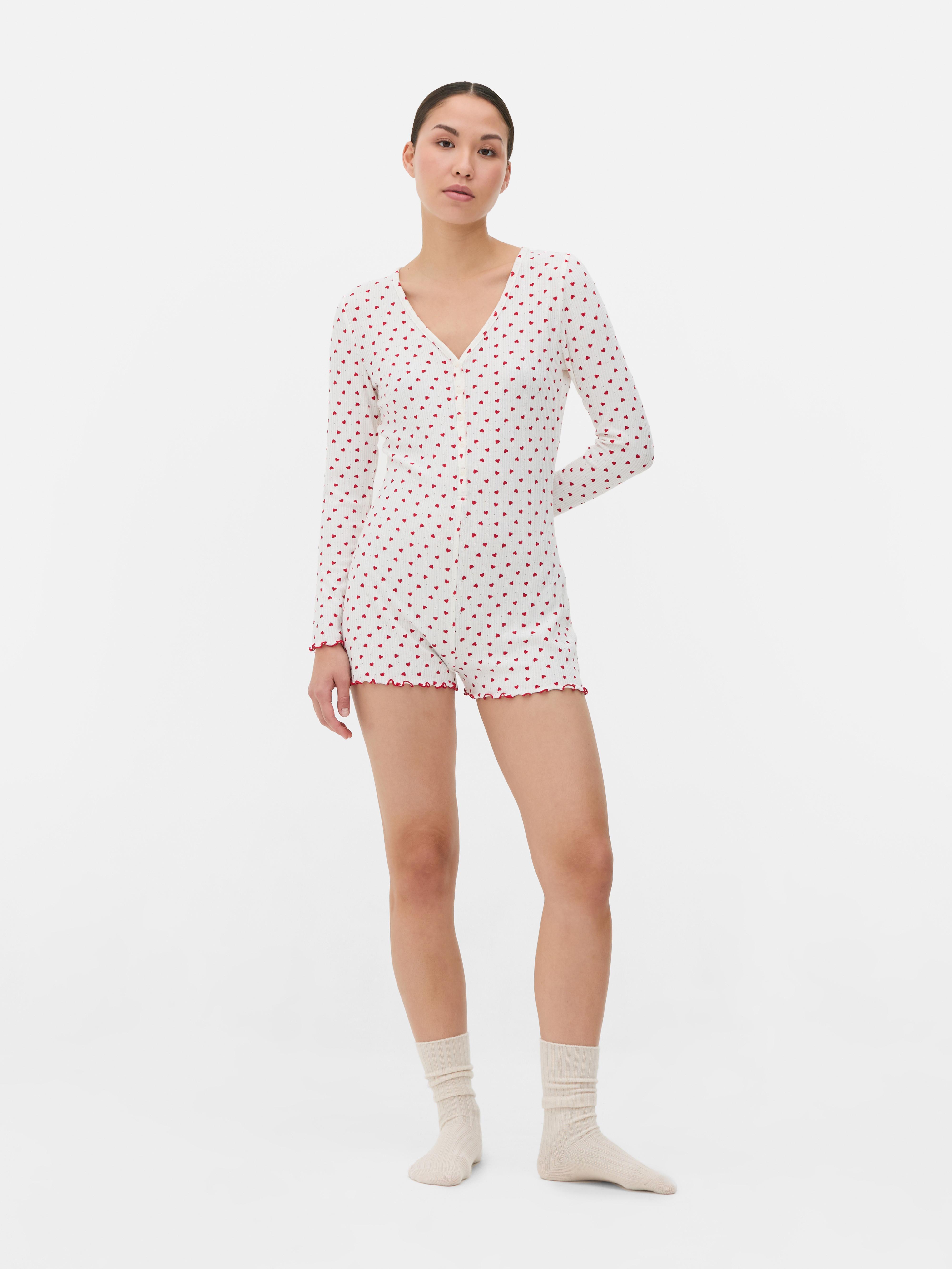 Salopetă de pijama cu model cu inimă. O salopetă de pijama confecționată din material moale cu nervuri, cu tiv festonat și model.