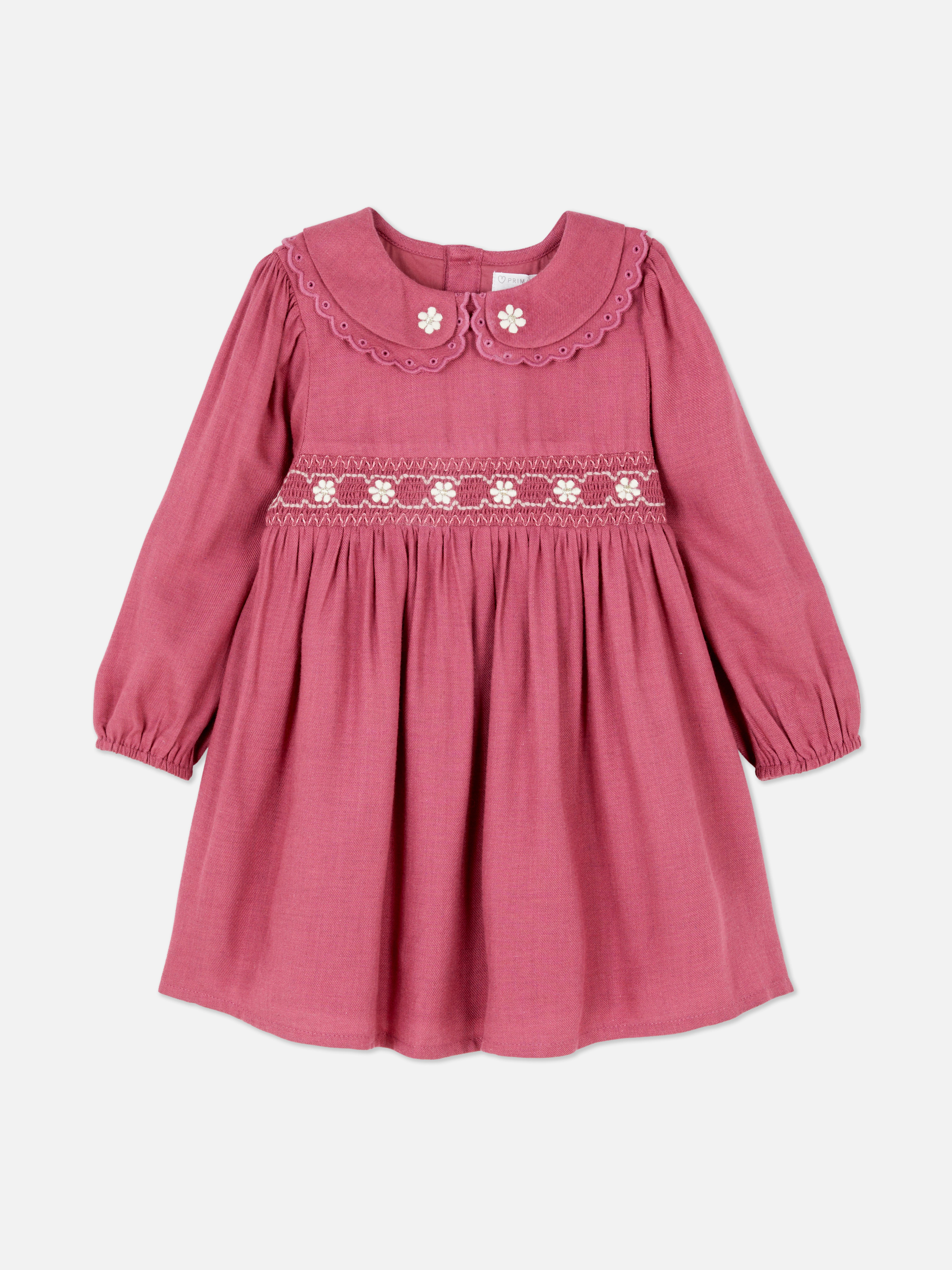 Rochie cu broderie florală. O rochie vaporoasă cu guler Peter Pan, mâneci lungi și închizătoare la spate.