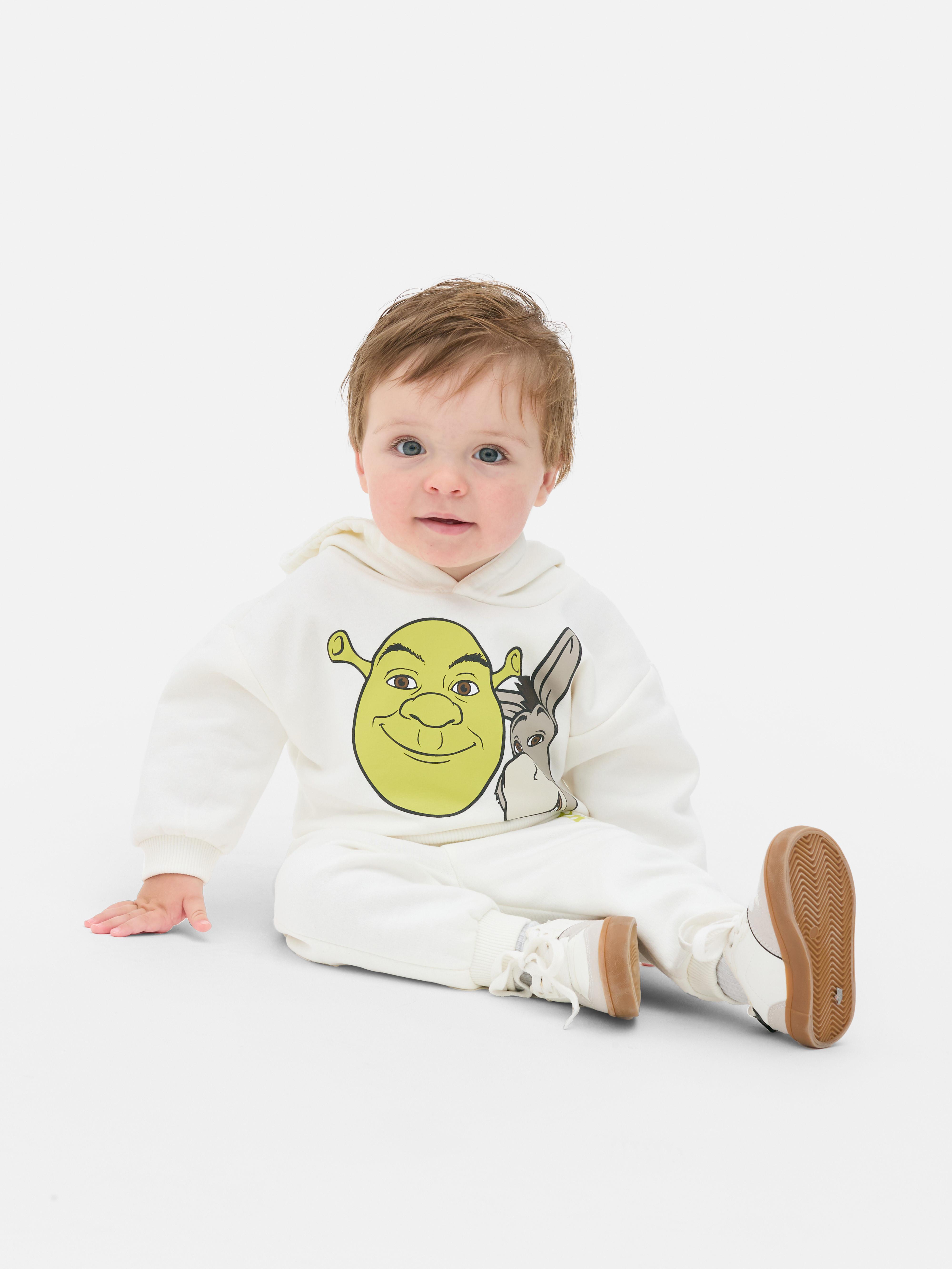 Hanorac și pantaloni de trening asortați cu tematică Shrek. Un hanorac cu tematică Shrek și pantaloni de trening asortați cu manșete la gleznă.