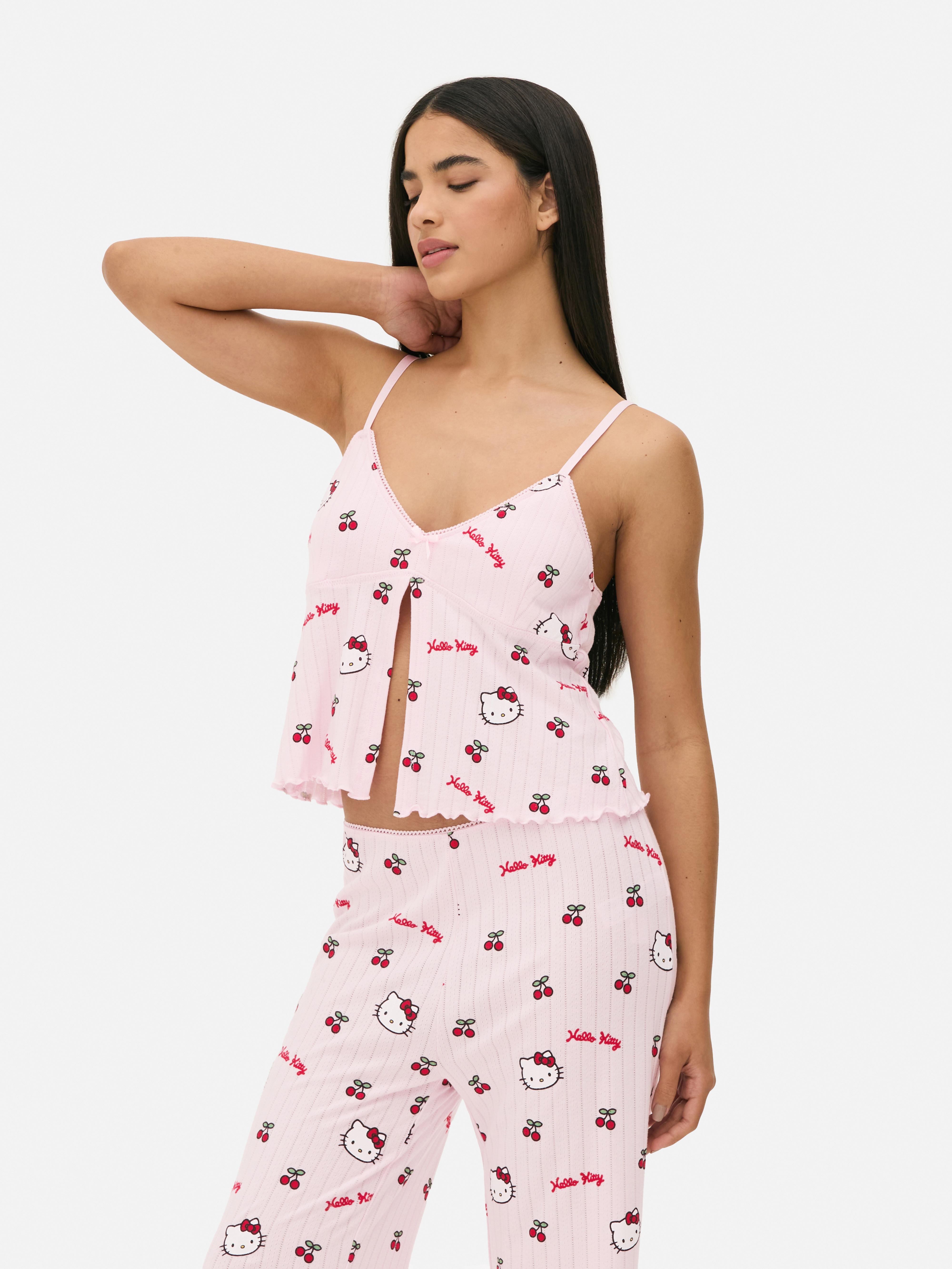 Top de pijama Hello Kitty cu imprimeu ajurat și camuflaj. Un top de pijama Hello Kitty cu ajurat, bretele reglabile, garnitură cu picot și tiv festonat.
