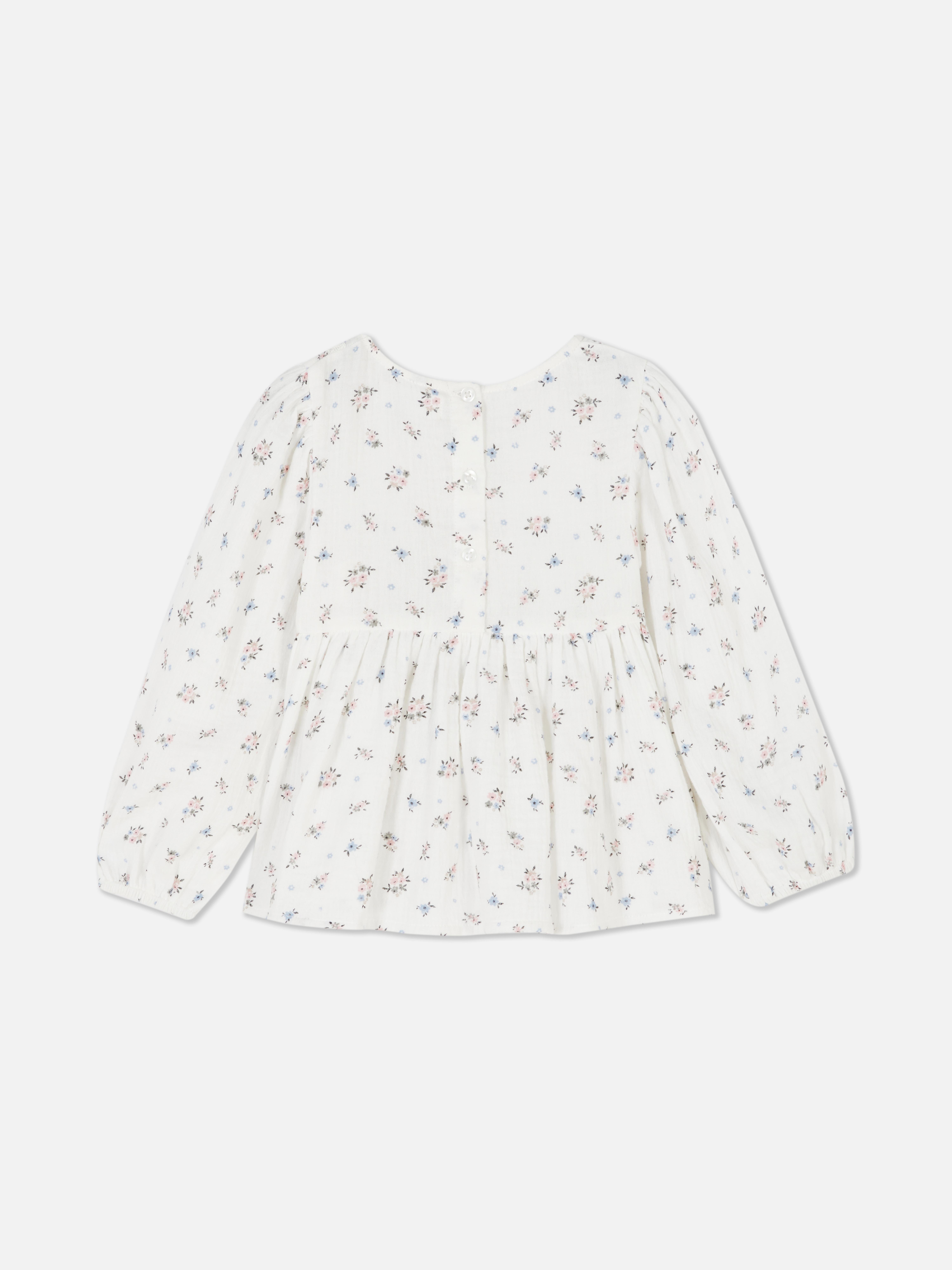 Langärmlige Bluse mit Blumenmuster Eine langärmlige Bluse mit Blumenmuster und Knopfverschluss am Rücken