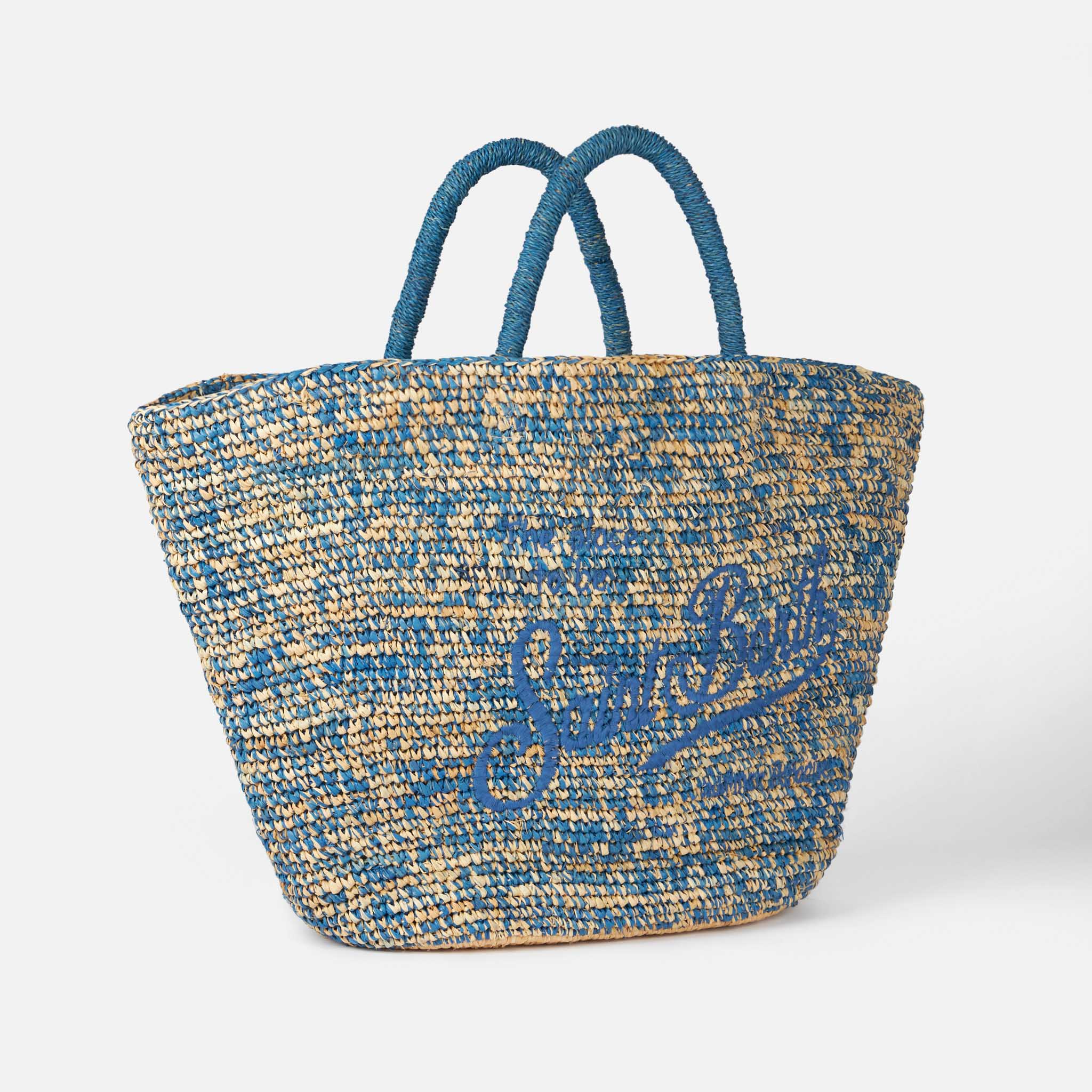 Blauw-witte raffia tas met borduurwerk aan de voorkant.