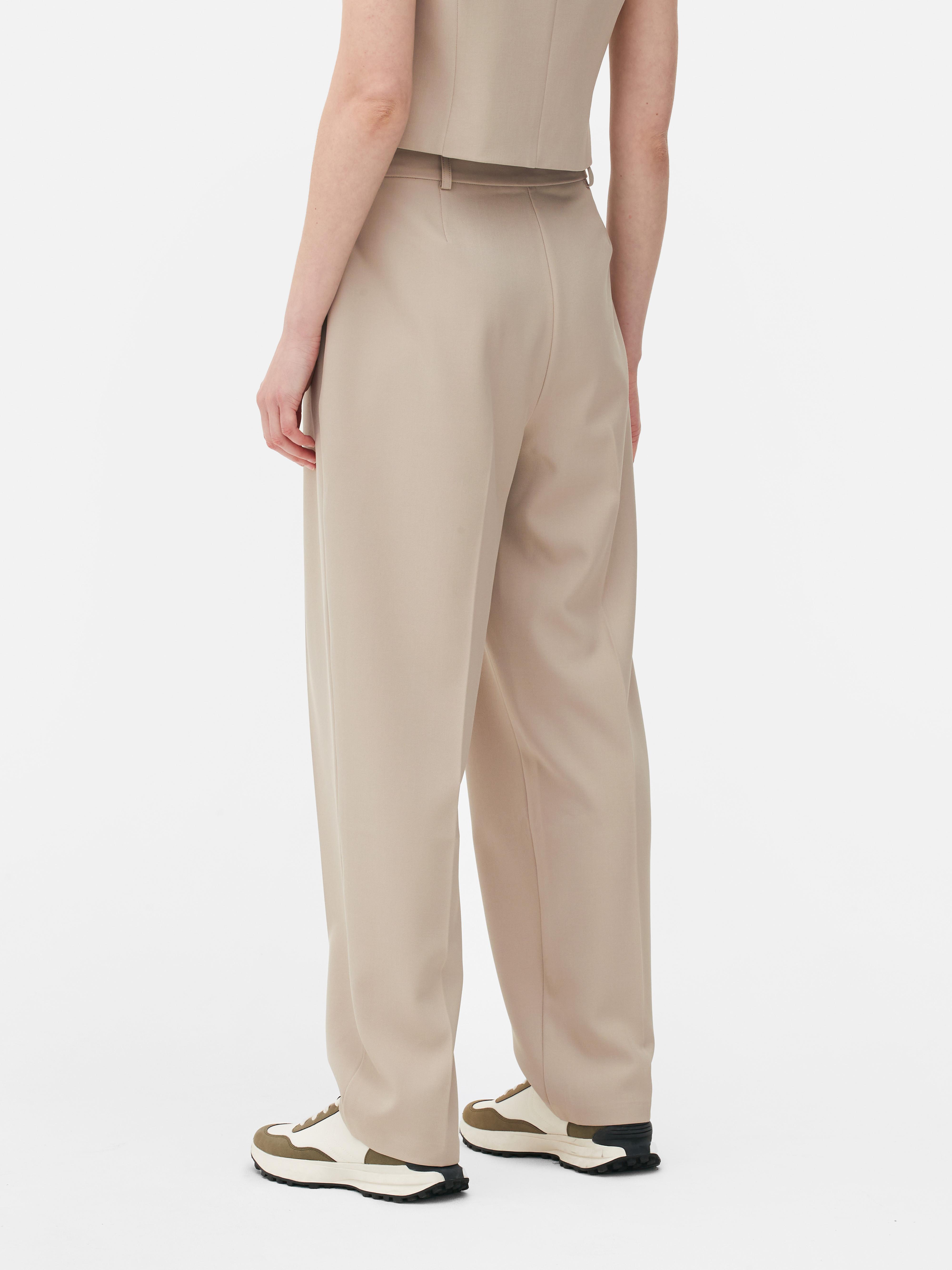 Passende Hose mit geradem Bein. Eine minimalistische Hose mit Bundfalten, geradem Schnitt und neutraler Farbe.