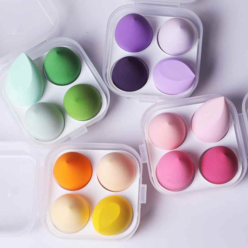 Conjunto de 4 acessórios de maquiagem feminina, incluindo esponja de maquiagem, aplicador de pó compacto e base, na cor roxa.