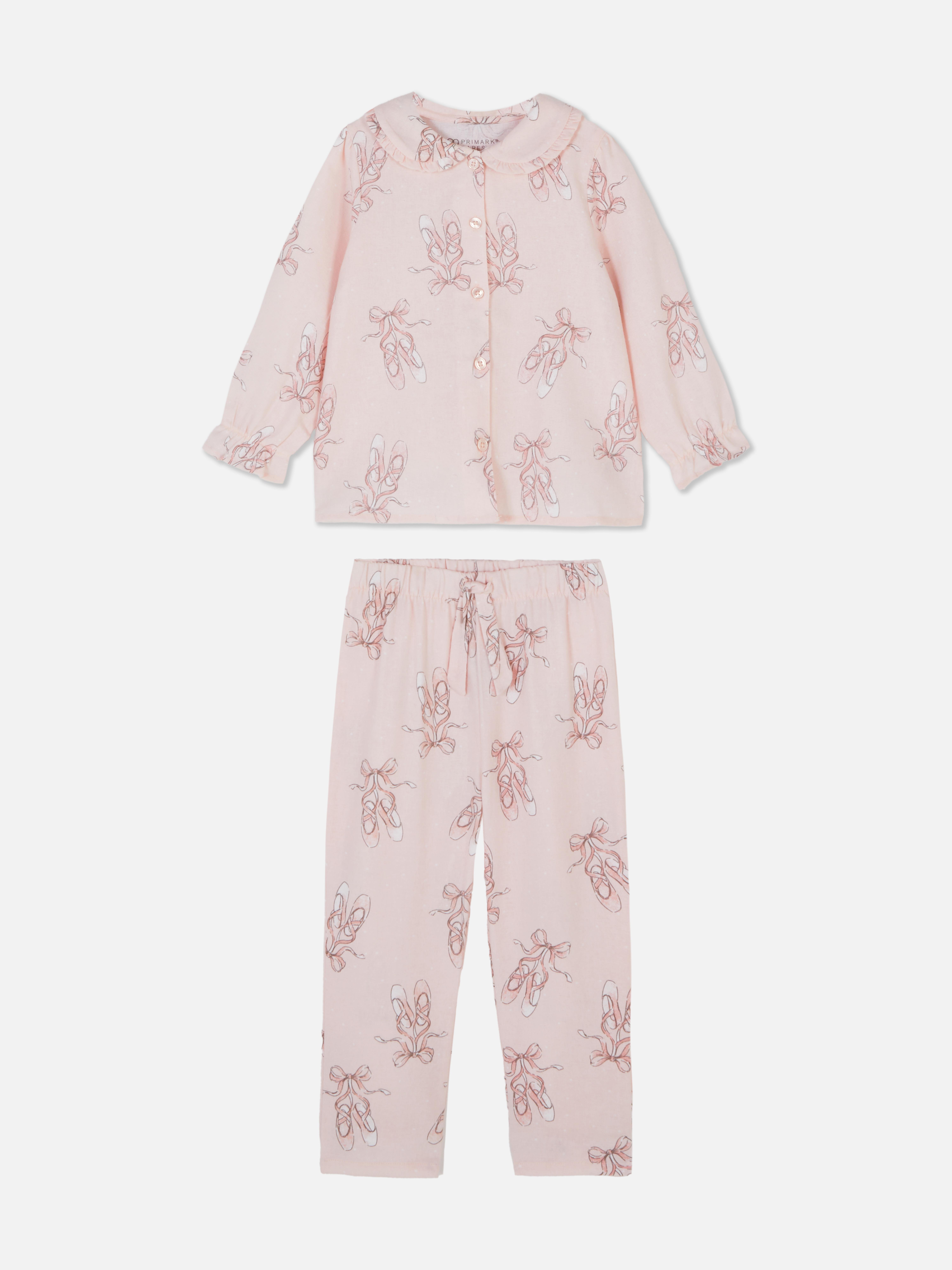Pyjama mit Ballettschuh-Motiv. Ein Pyjama mit Oberteil mit Kragen und langer Hose mit Ballettschuh-Muster.