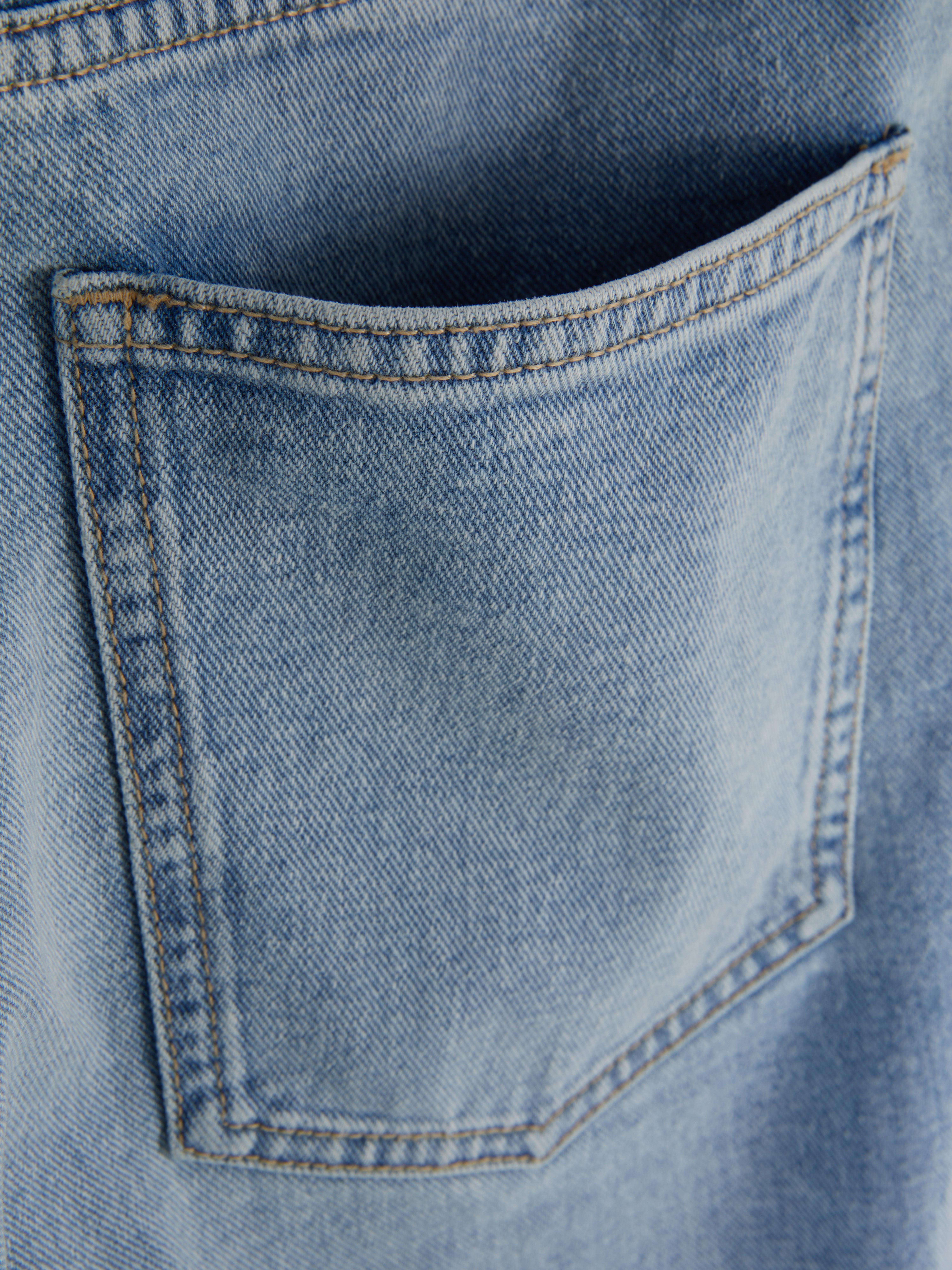 Jeans con striscia laterale e gamba larga. Questi jeans hanno gamba larga, cinque tasche, passanti per la cintura e chiusura nascosta sul davanti.