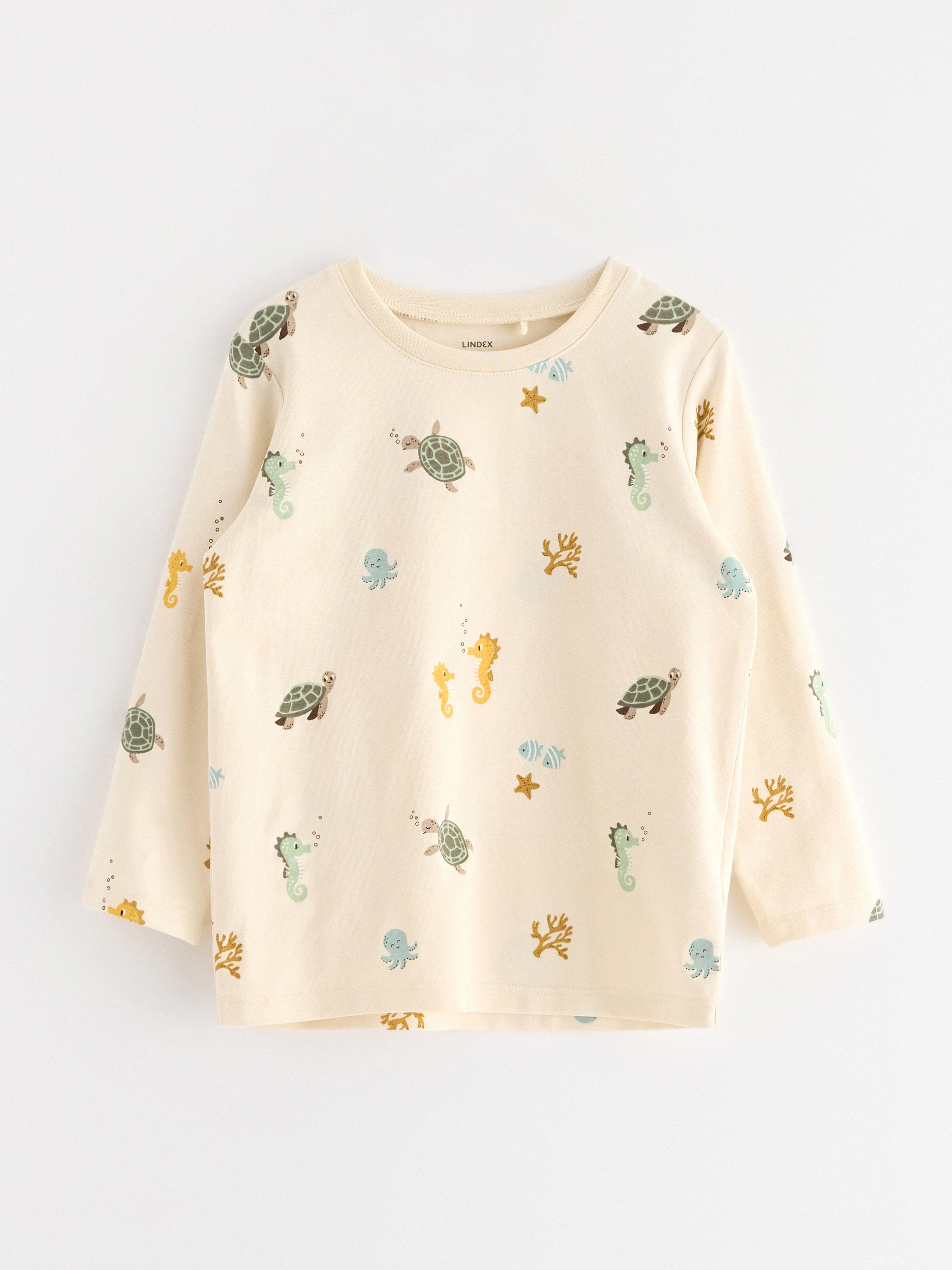 Top de manga larga color beige claro.