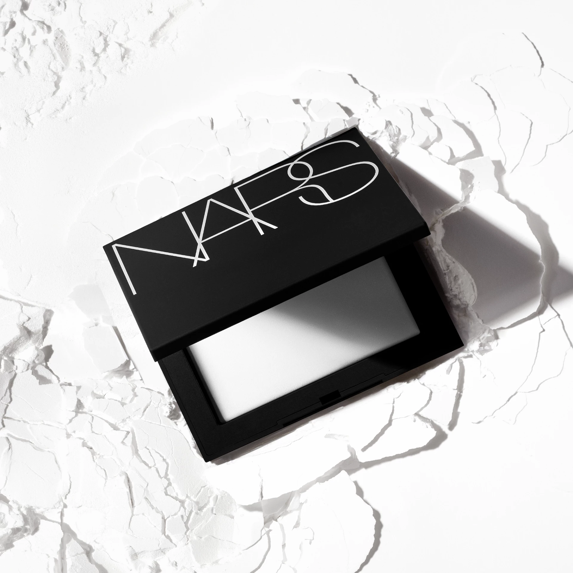 NARS prešani kristalni puder za fiksiranje koji reflektira svjetlost