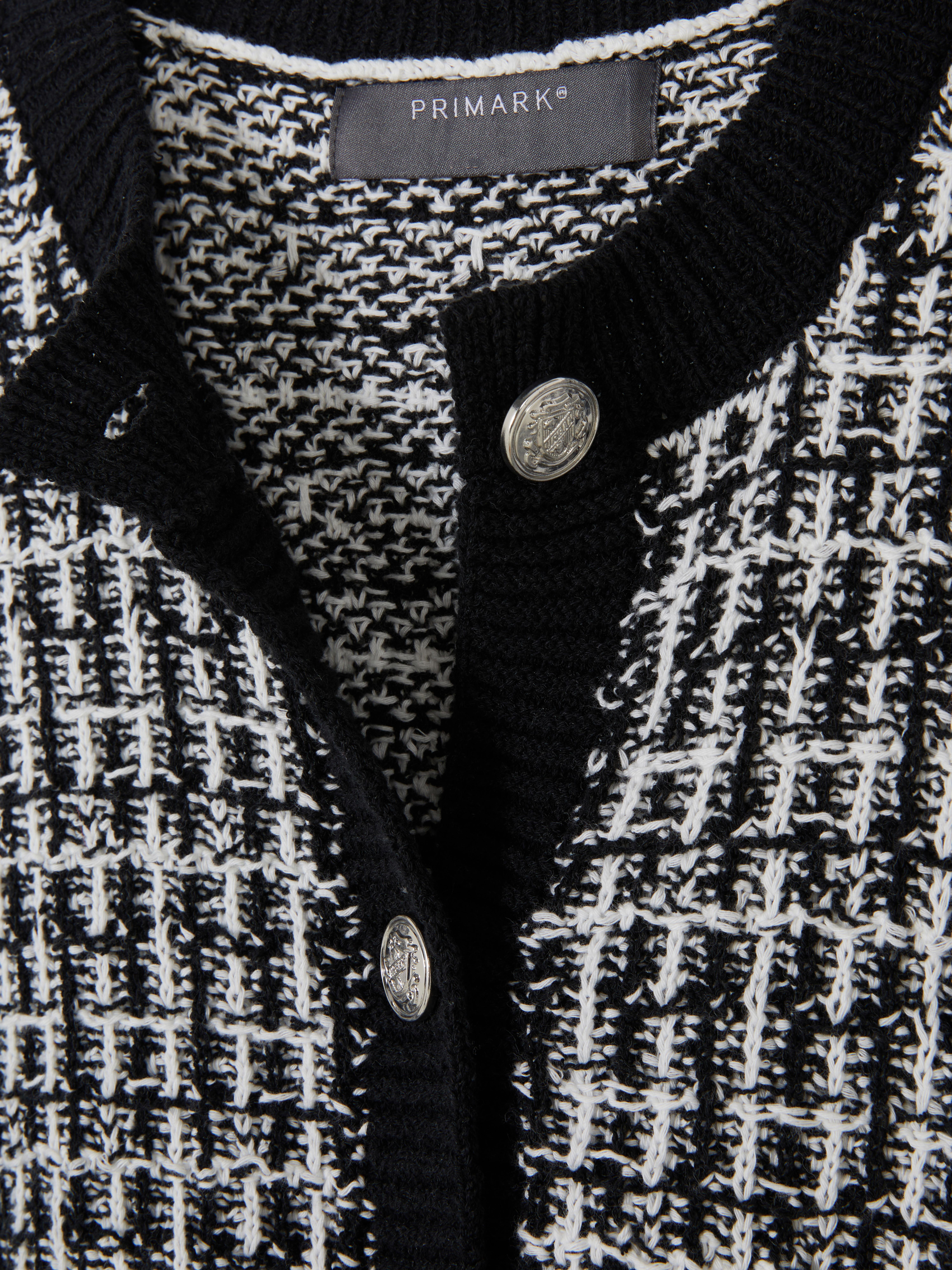 Tweed-Strickjacke mit Knöpfen. Eine Tweed-Strickjacke mit Knopfleiste, gerippten Bündchen und Taschen.