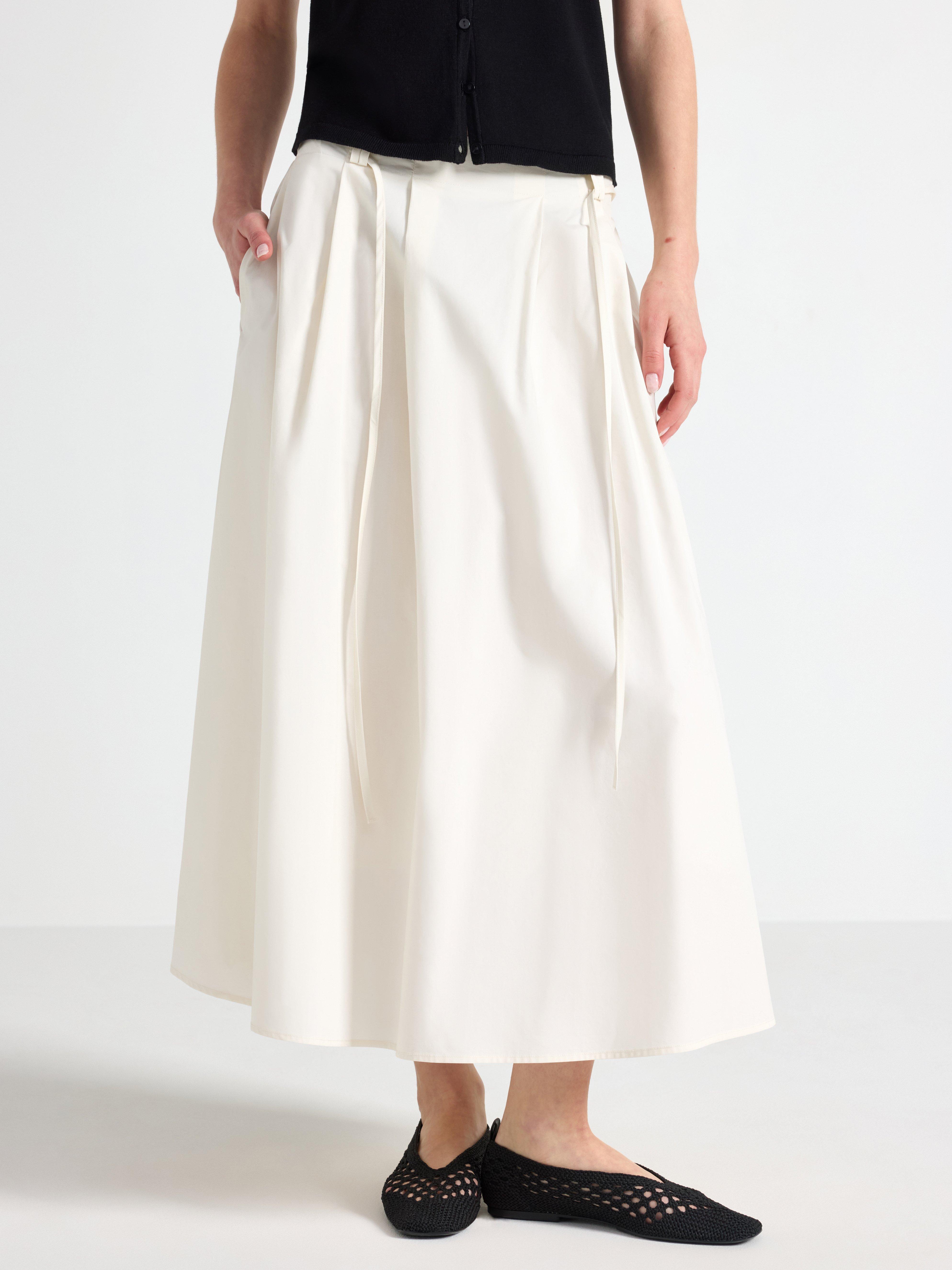 Falda midi plisada, color blanco claro.