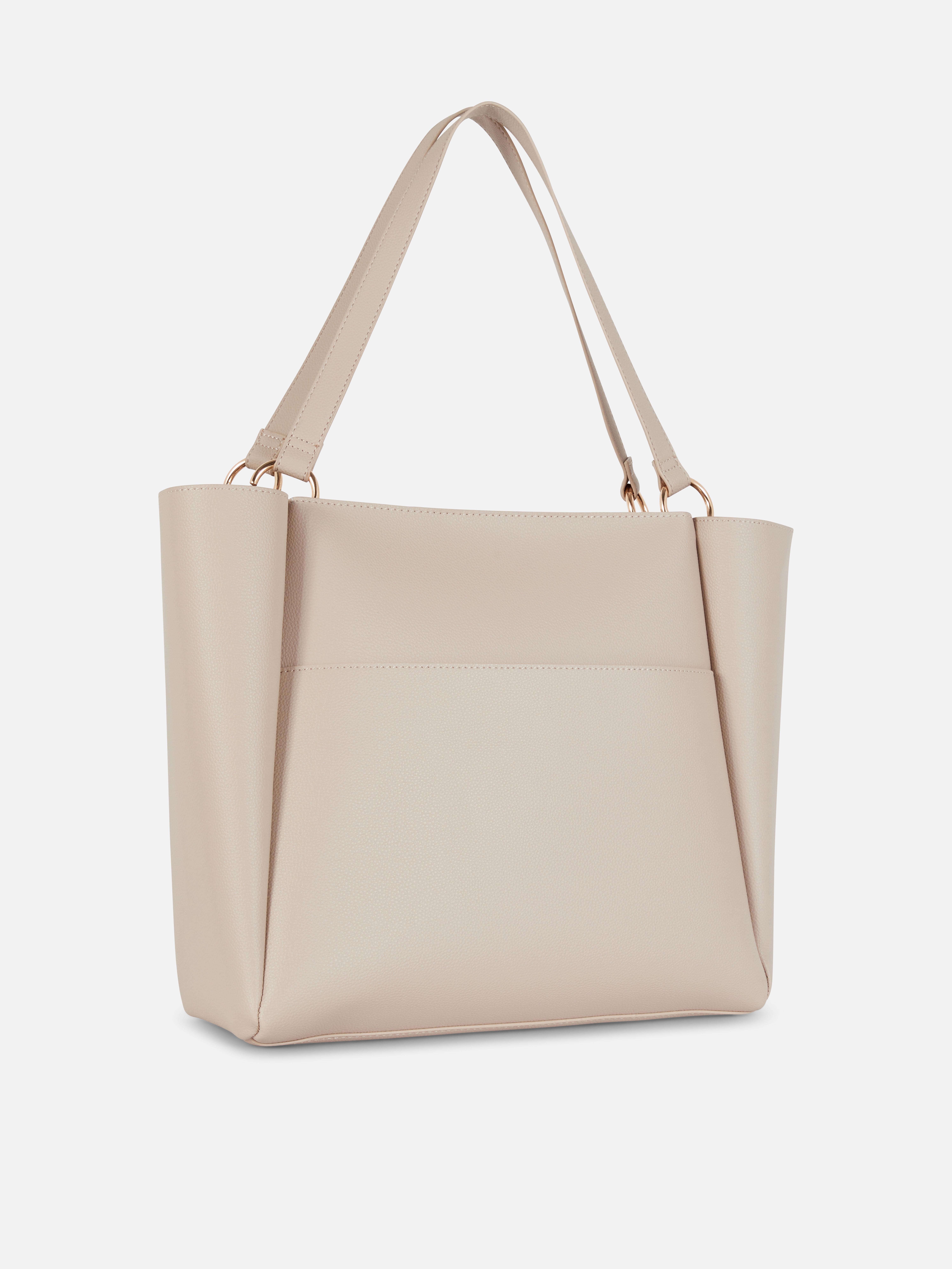 Geantă shopper din piele ecologică. O geantă shopper cu aspect de piele și accesorii moderne în formă de inel.
