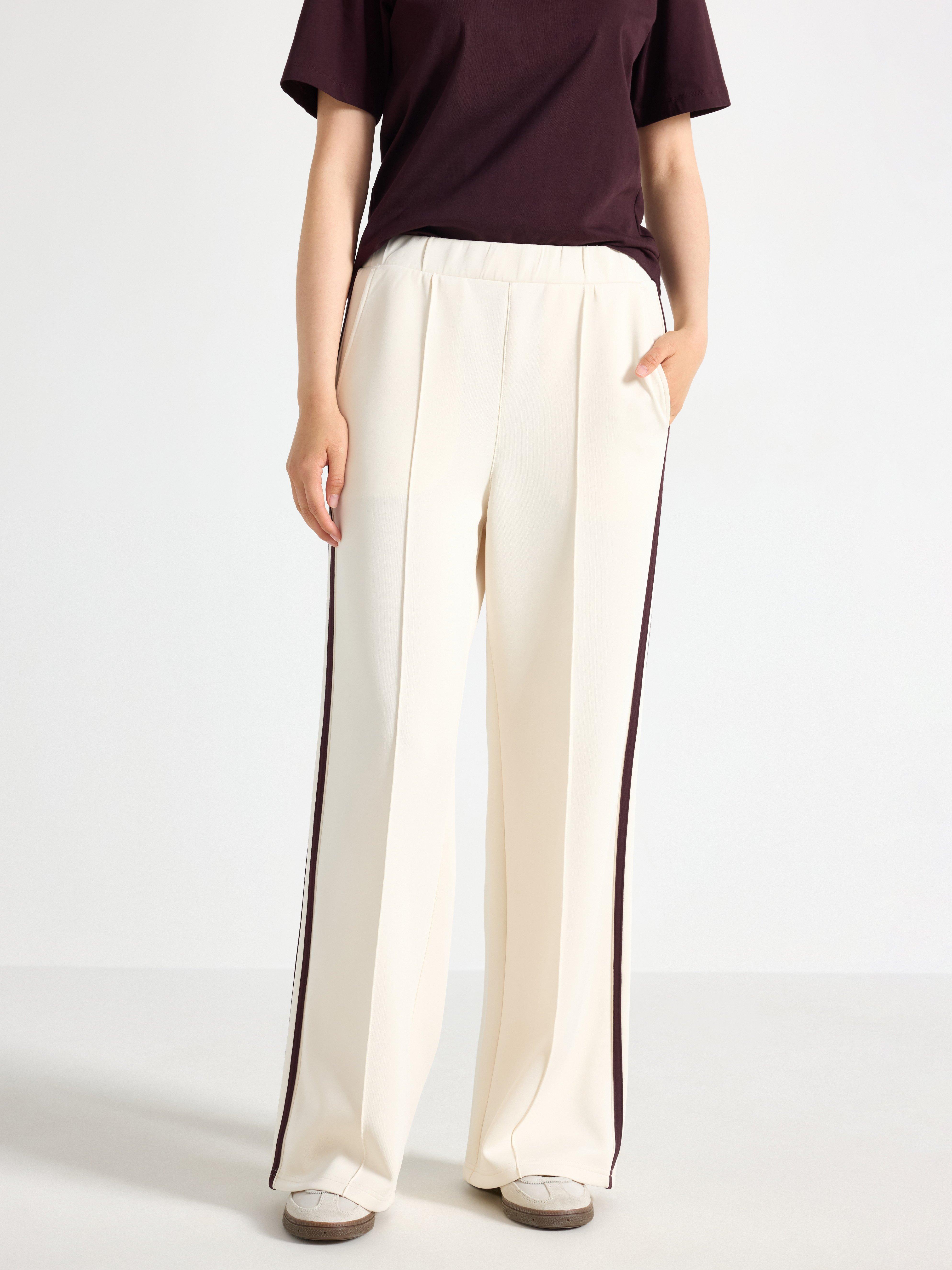 Pantalones anchos de punto color beige claro.