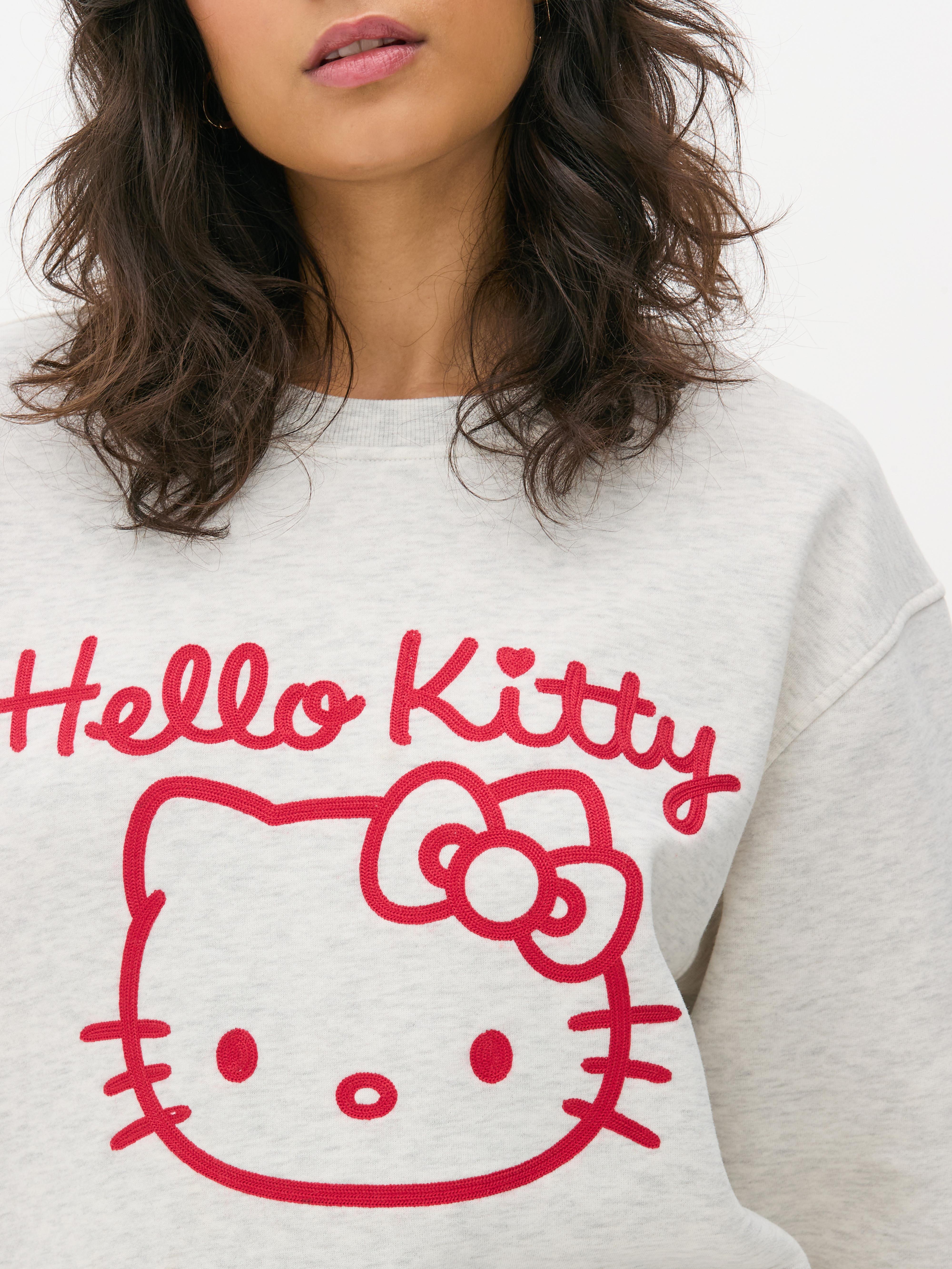 Hanorac cu imprimeu Hello Kitty Un hanorac cu umeri căzuți, manșete cu nervuri și imprimeu Hello Kitty