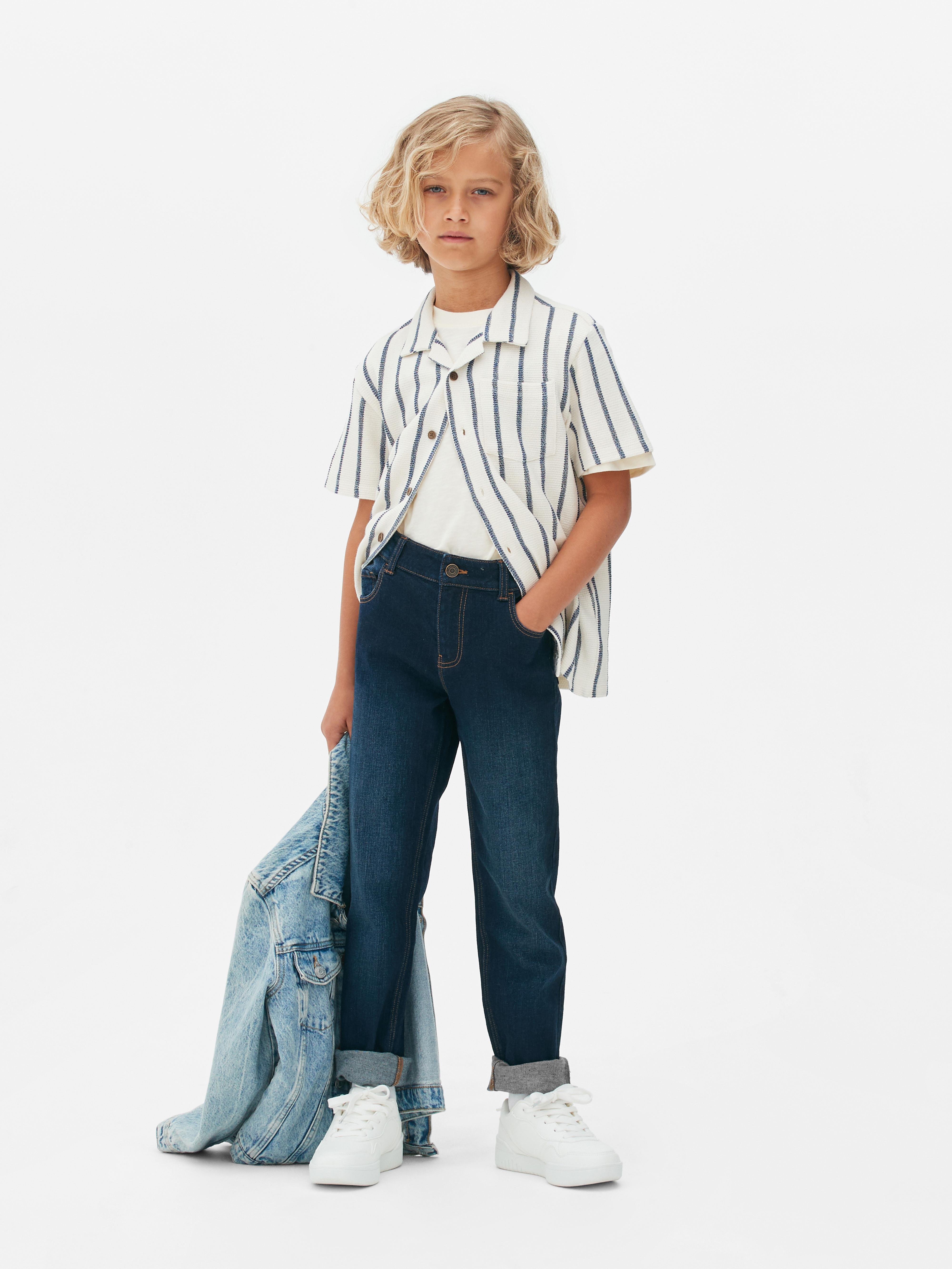 Schmal geschnittene Jeans für Jungen. Diese schmal geschnittenen Jeans mit Gürtelschlaufen und Knöpfen verleihen ihrer Jeanskollektion das gewisse Extra.