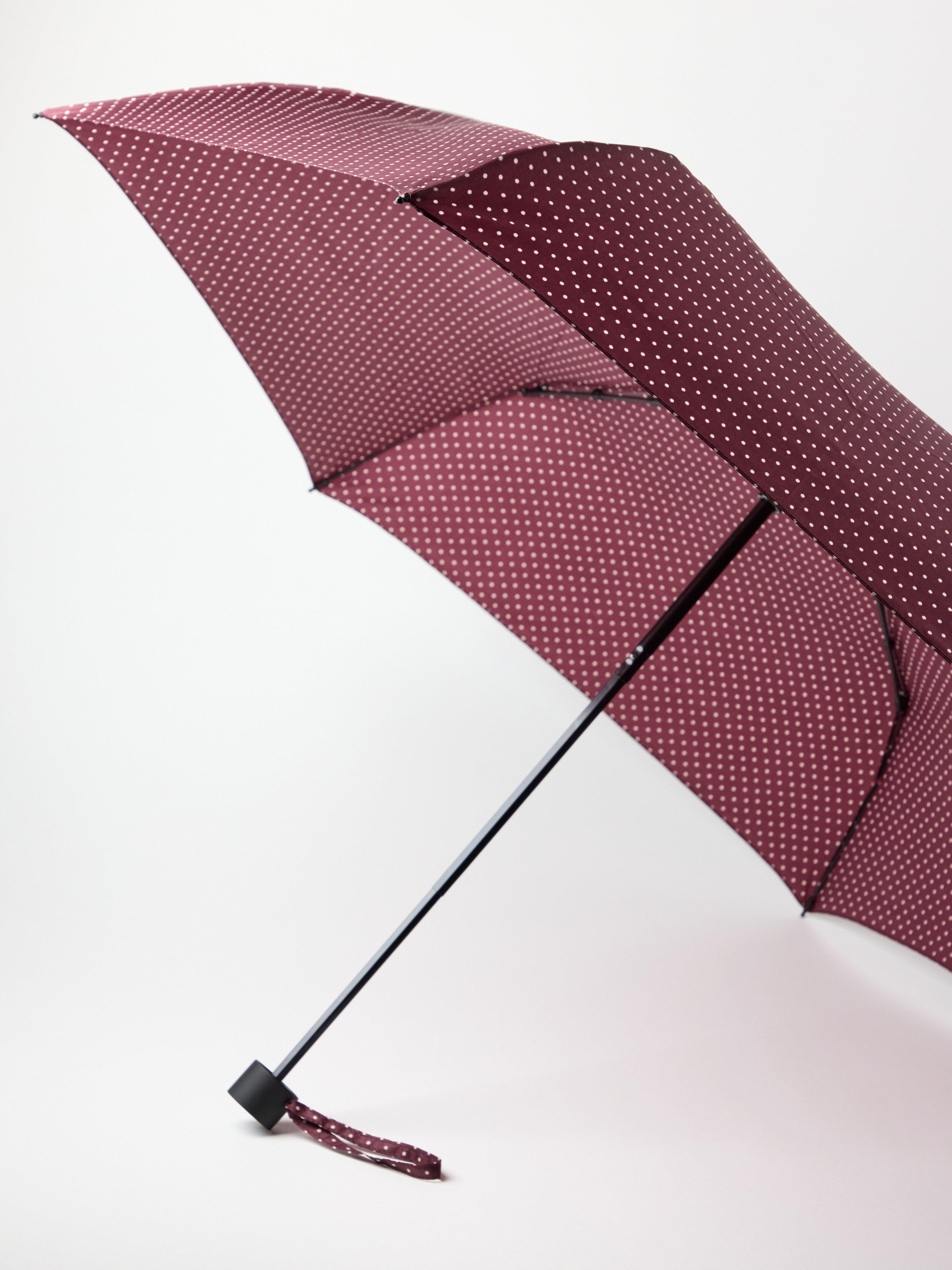 Guarda-chuva vermelho escuro empoeirado