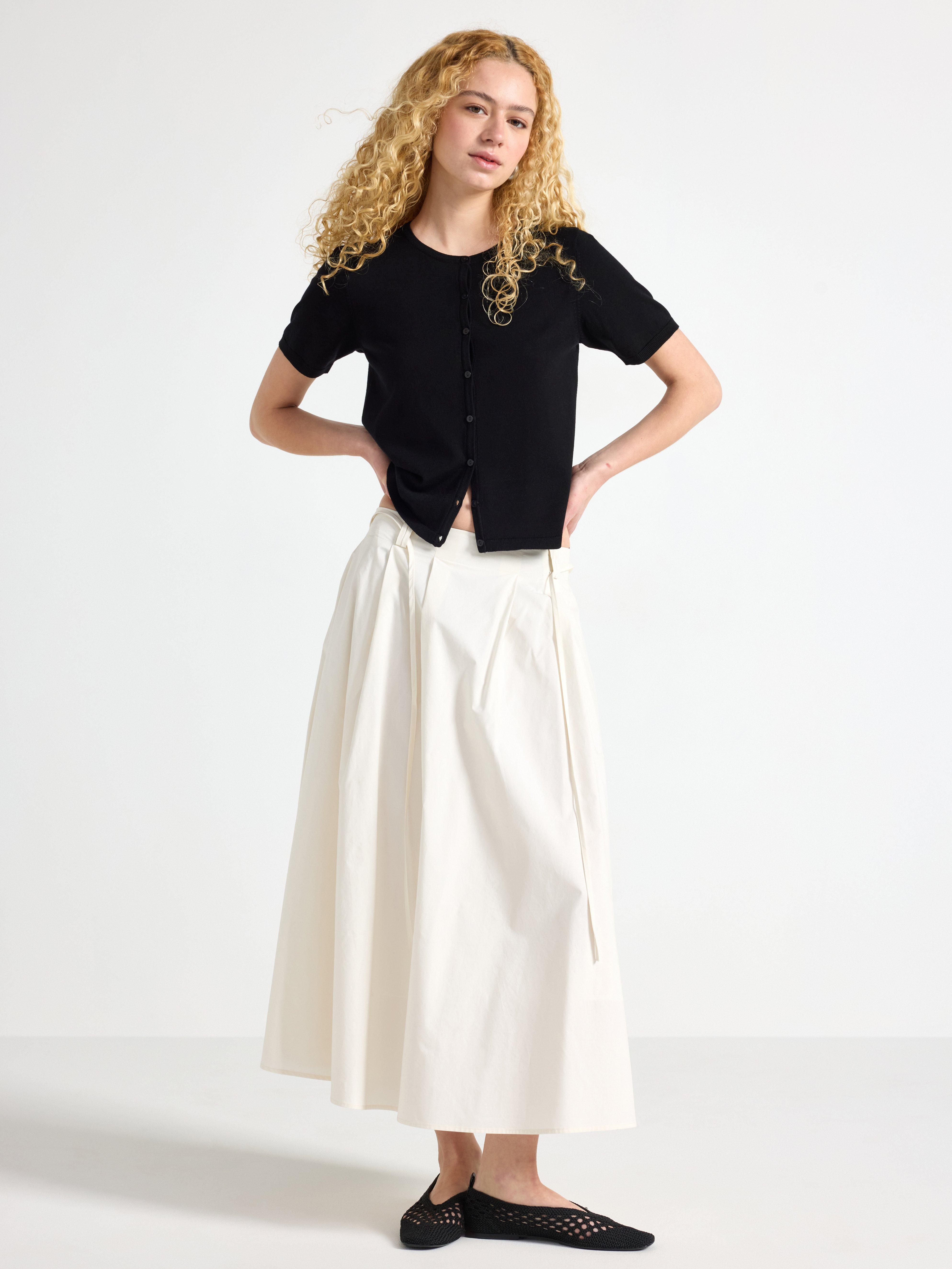 Falda midi plisada, color blanco claro.