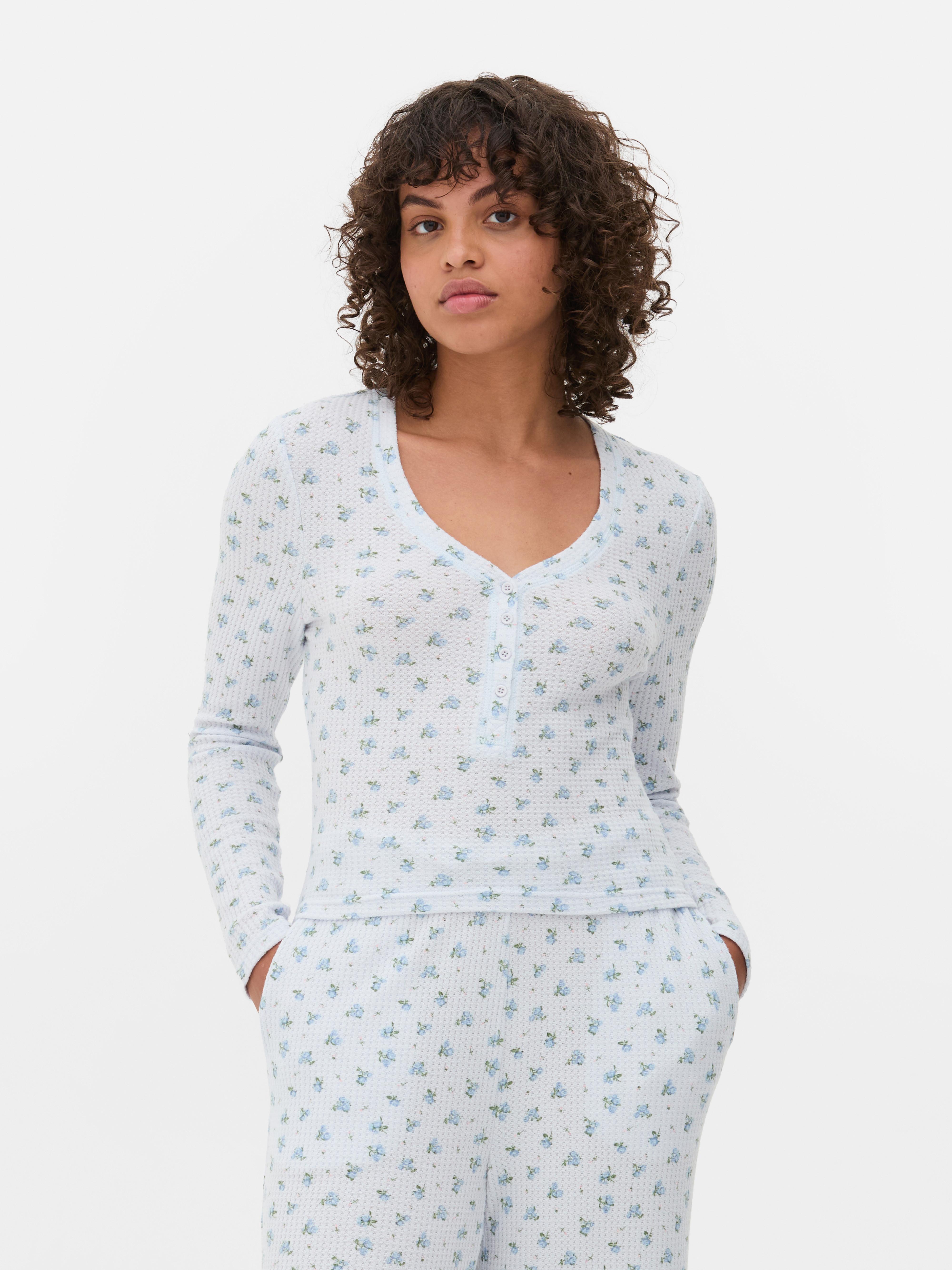 Top de pijama cu mâneci lungi și imprimeu floral. Aceste pijamale cu textură tip waffle au decolteu în V, închidere cu nasturi și mâneci lungi.