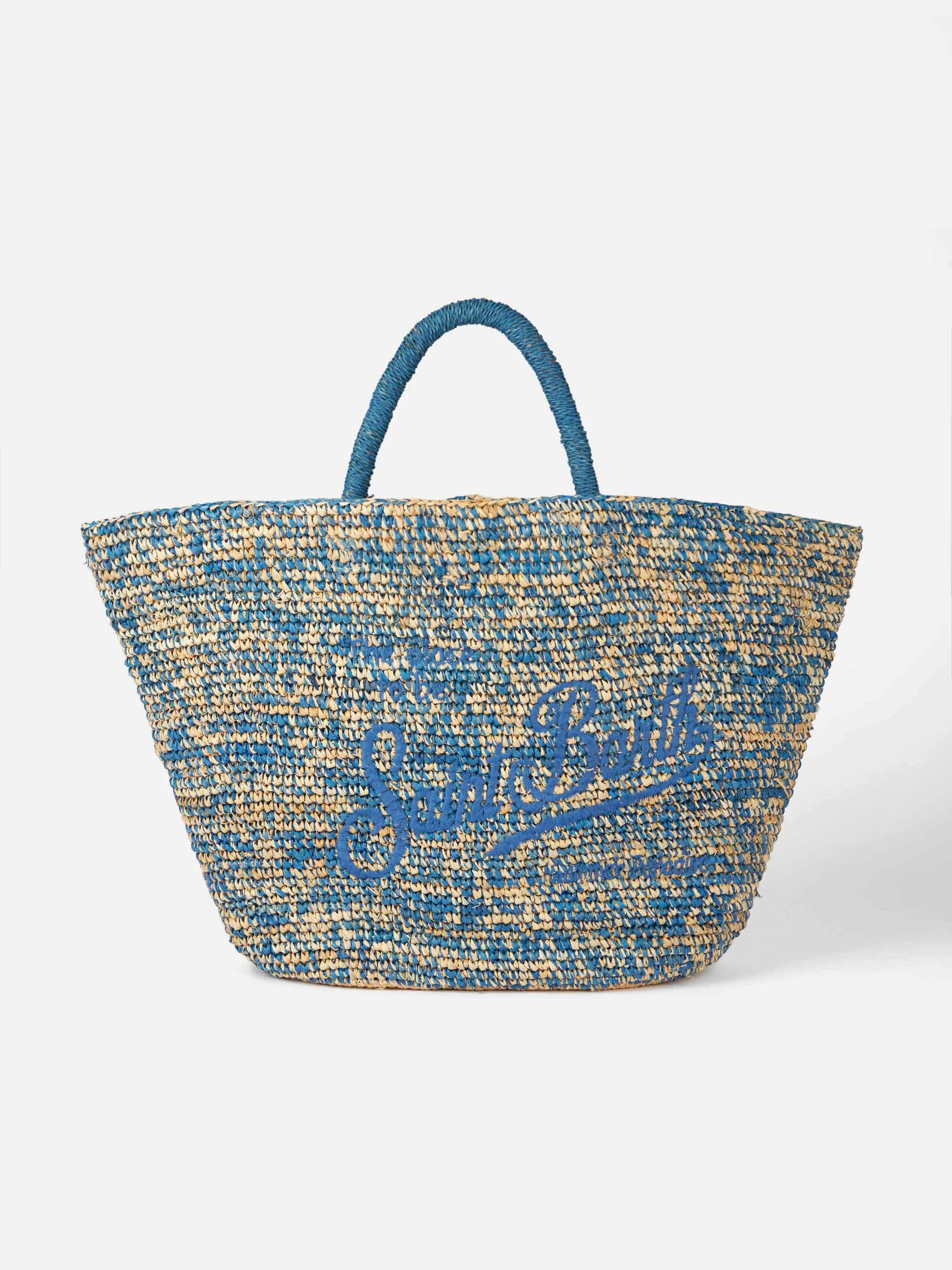 Blauw-witte raffia tas met borduurwerk aan de voorkant.