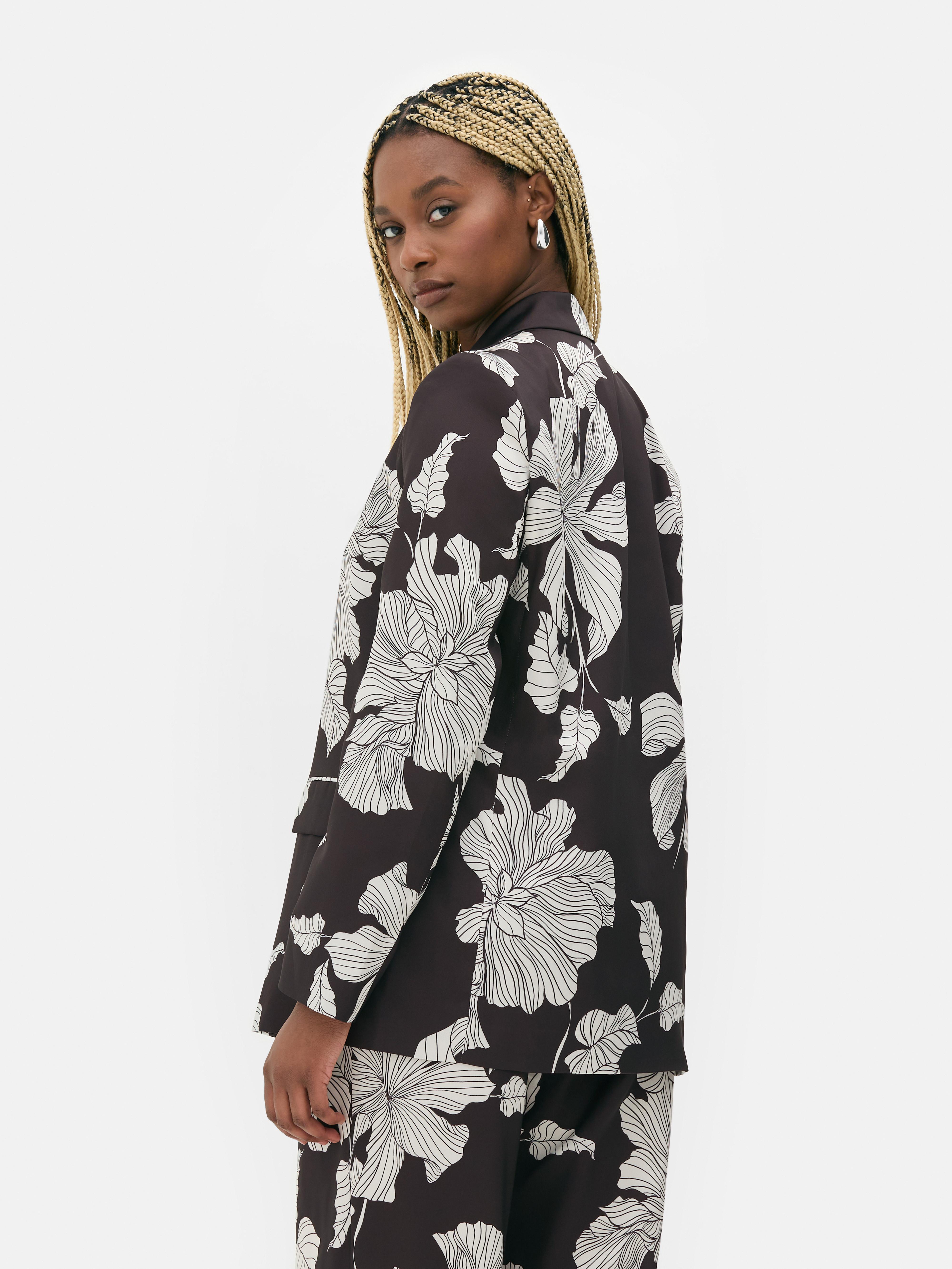 Sacou satinat cu un singur rând de nasturi. Acest sacou smoking cu model floral contrastant are pantaloni asortați.