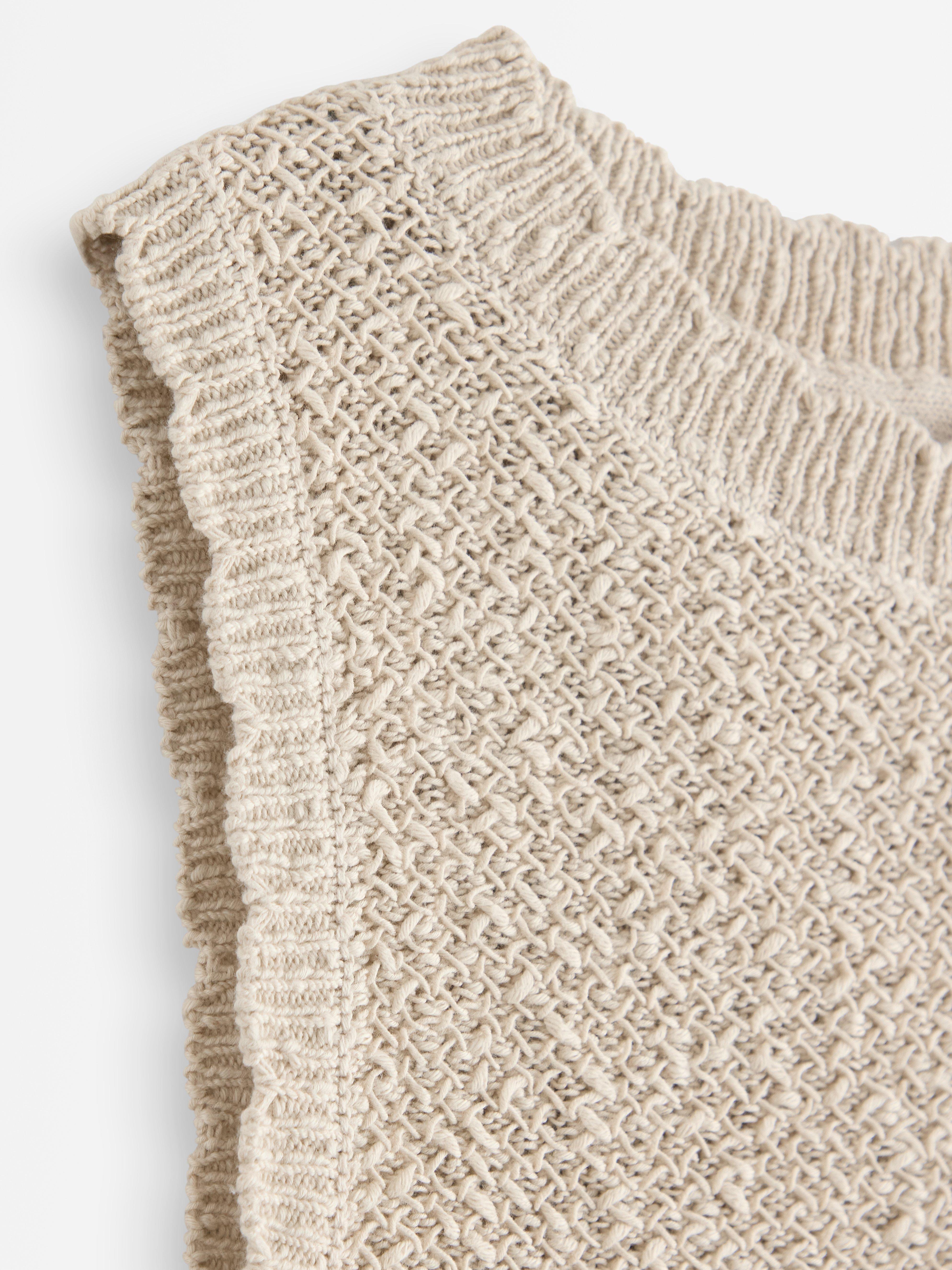 Top de punto con escote barco, color beige claro.