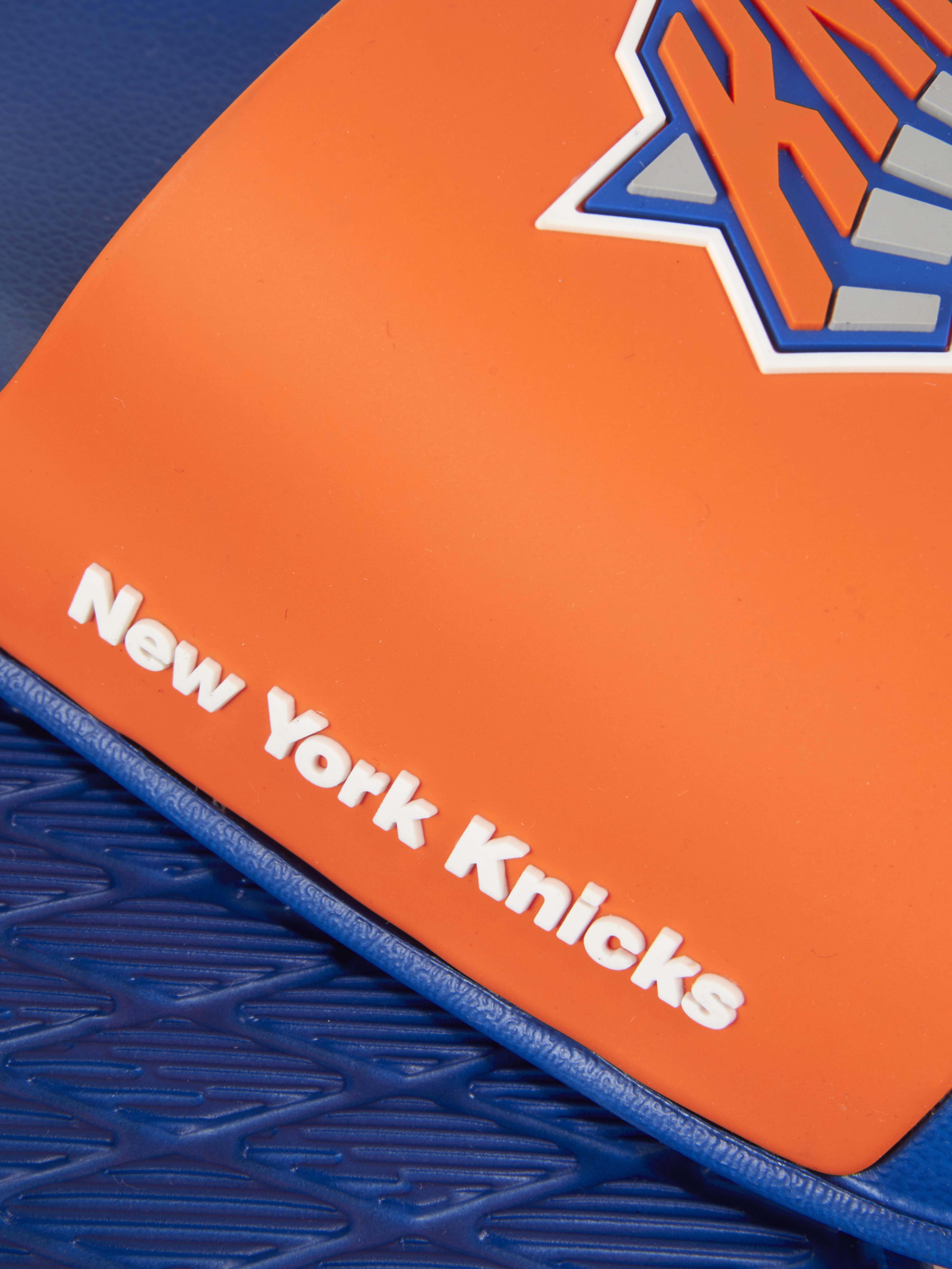 Șlapi NBA New York Knicks O pereche de șlapi colorați cu talpă interioară turnată și curea lată cu insignă Knicks