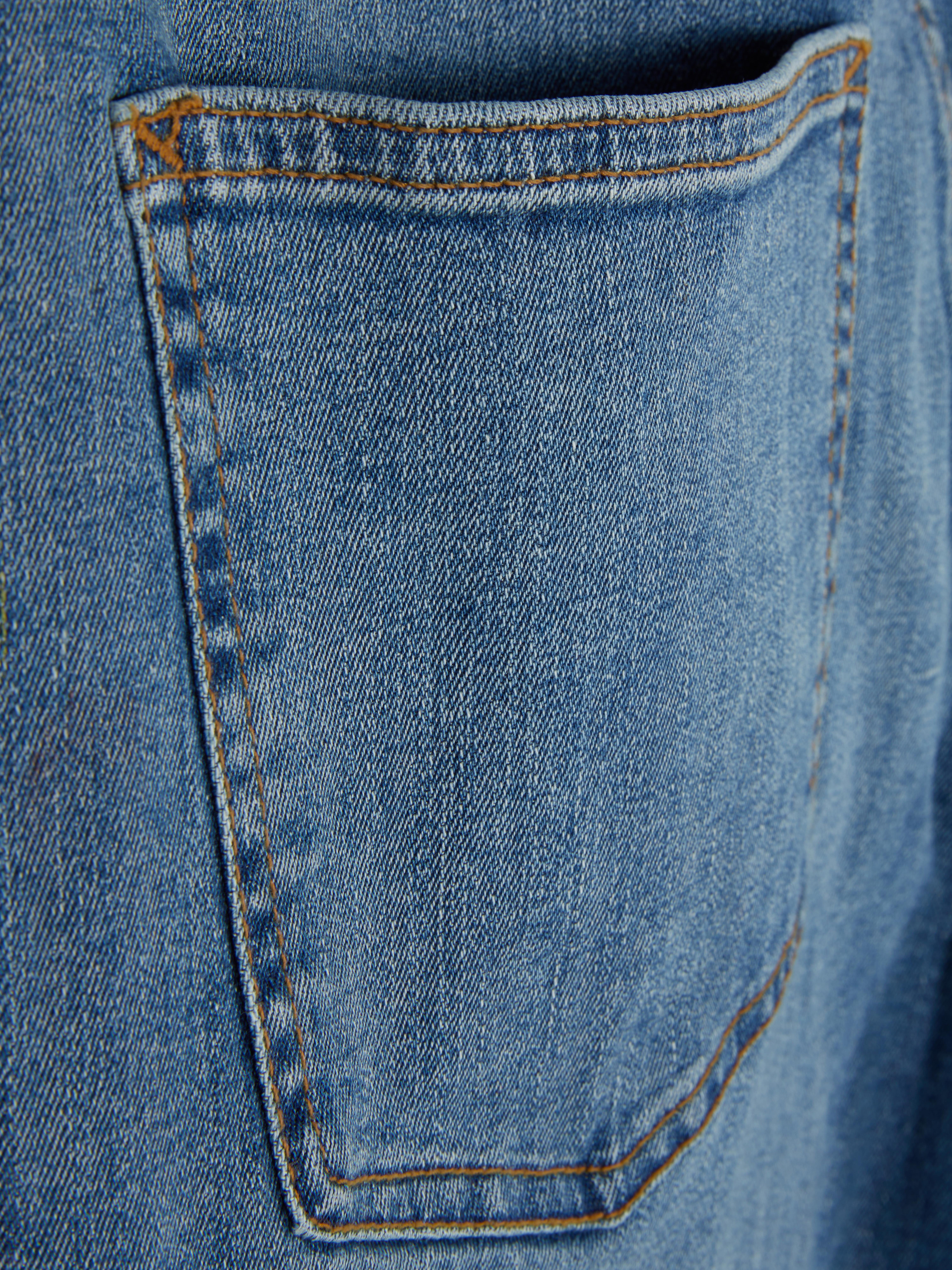 Blugi elastici, slim fit. Blugi mulați cu închidere cu nasturi, cinci buzunare și găici pentru curea.