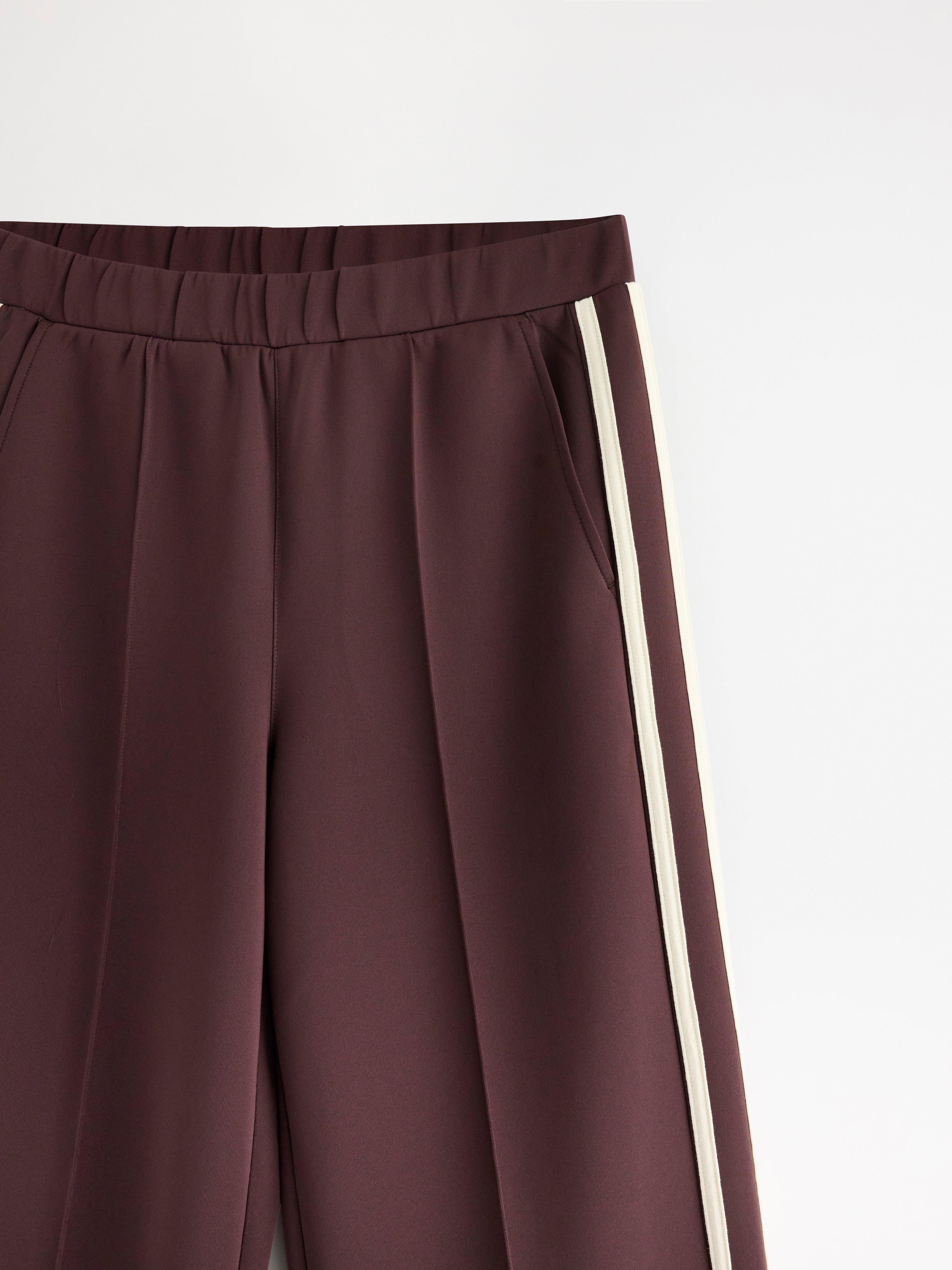 Pantalones de pierna ancha en punto color rojo oscuro empolvado.