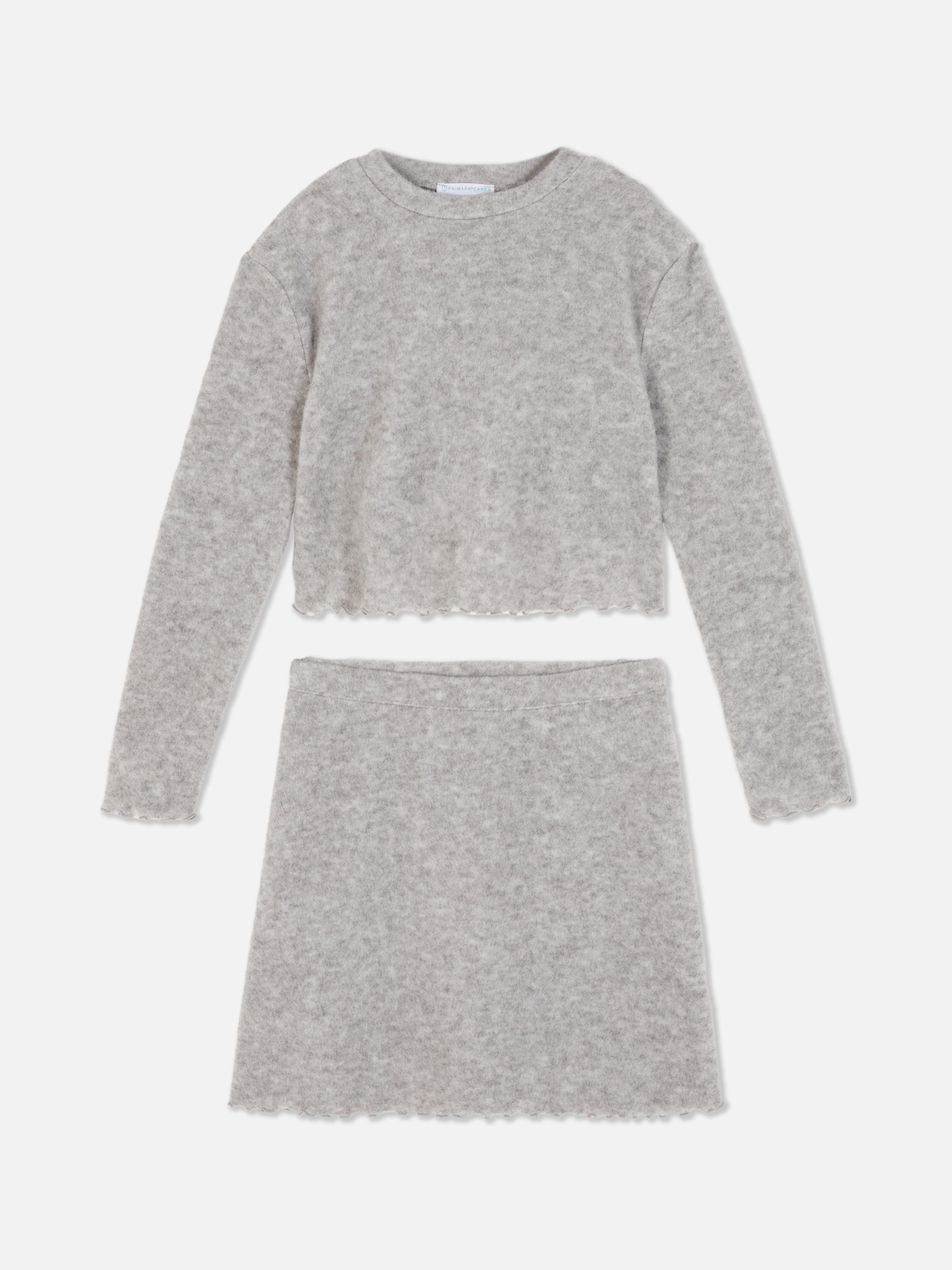 Set van geborsteld T-shirt met lange mouwen en rok Een geborstelde set van een T-shirt met lange mouwen en rok met geschulpte randen