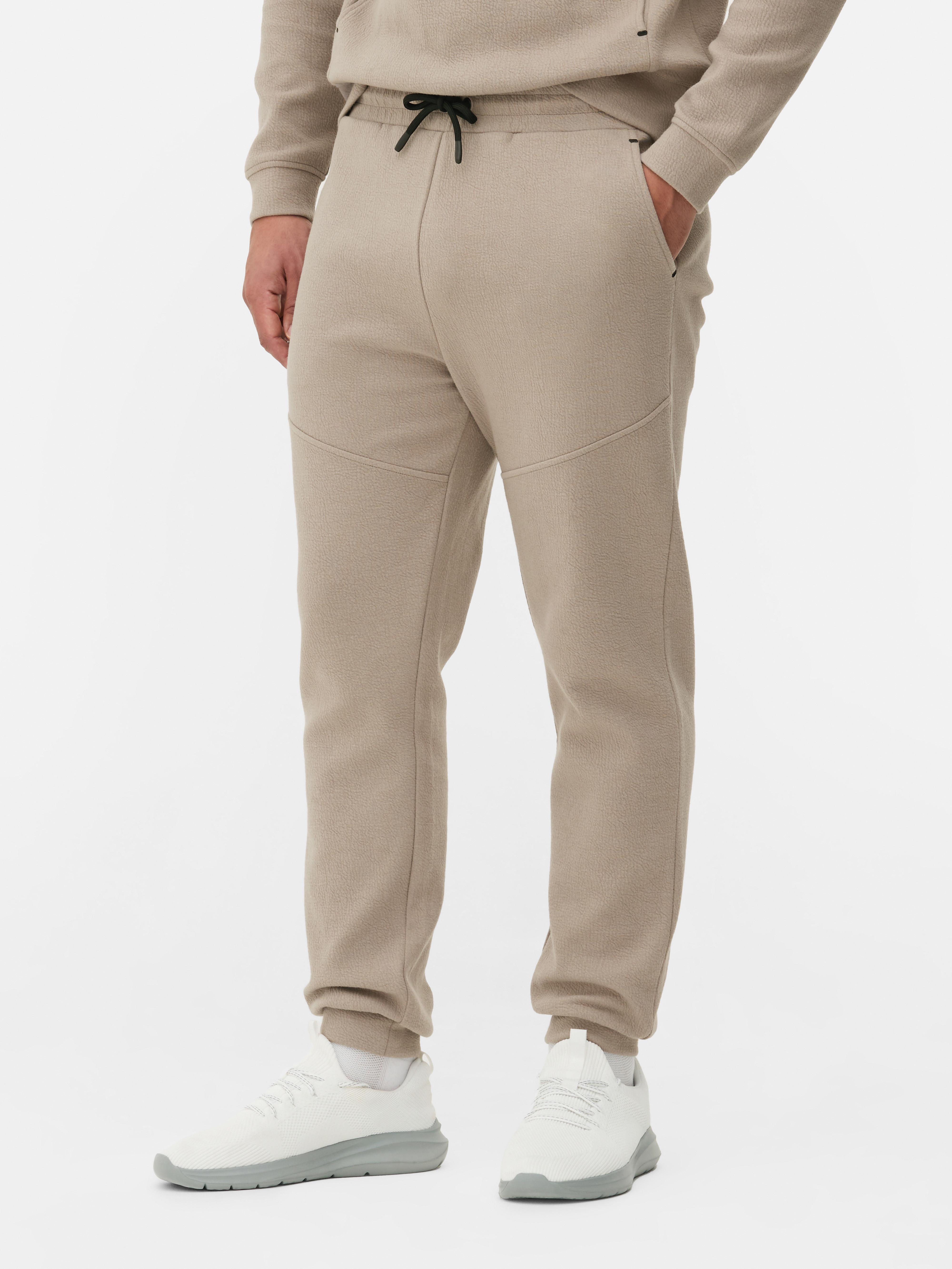 Pantaloni de trening texturați cu șnur de strângere Pantaloni de trening cu șnur de strângere, buzunare laterale, clinuri și manșete la gleznă