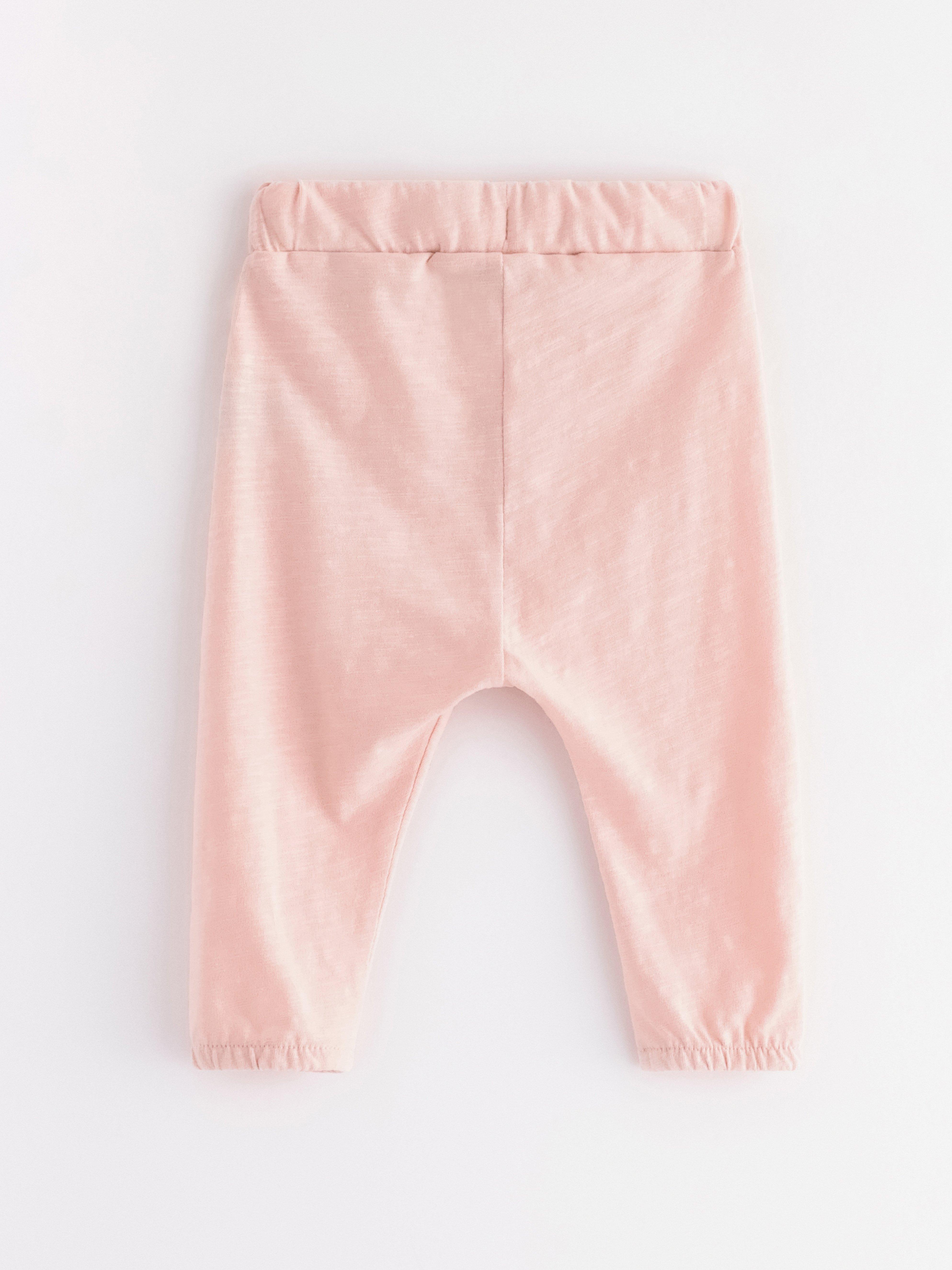 Pantalones deportivos de punto flameado, color rosa claro empolvado.