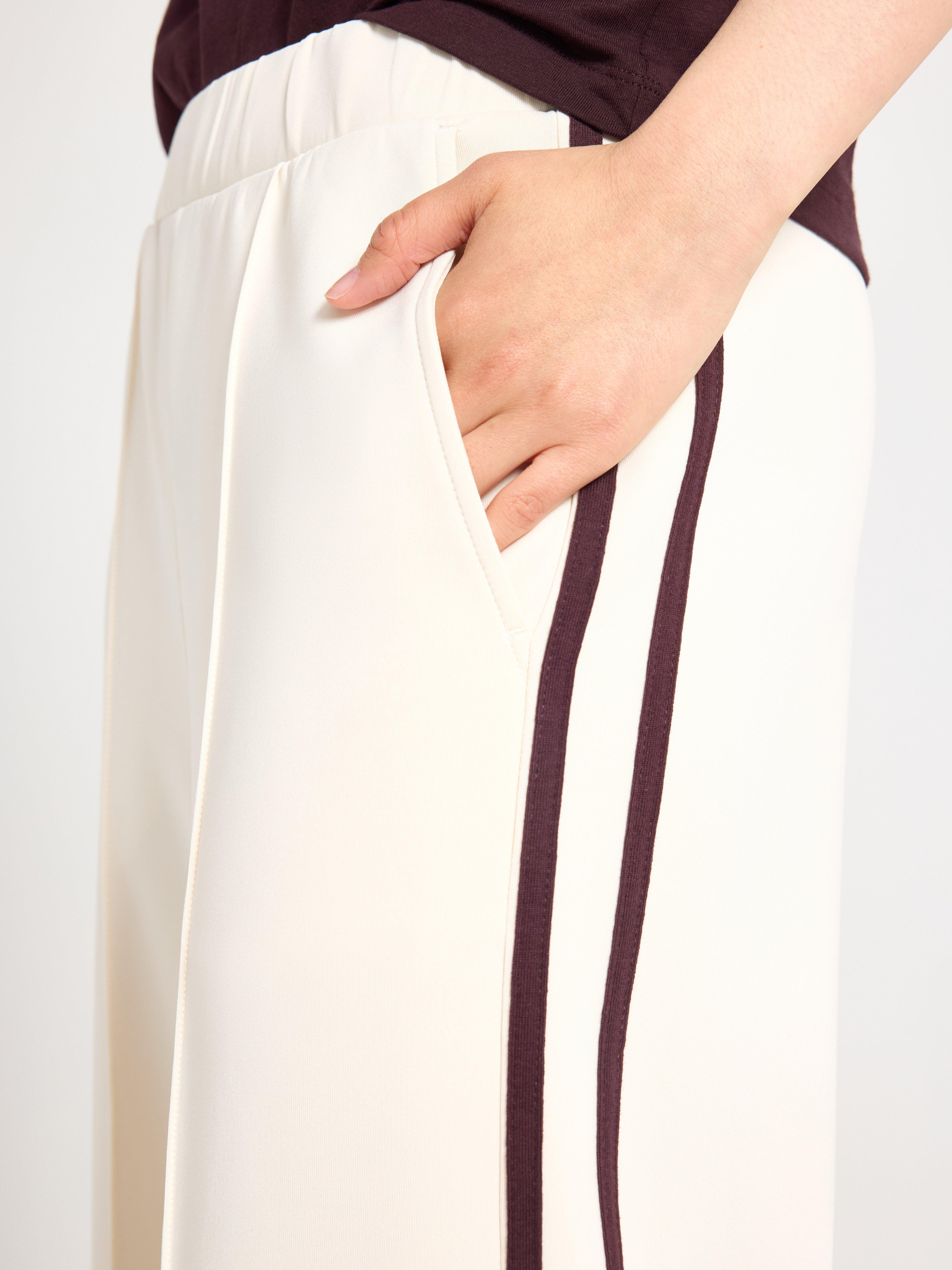 Pantalones anchos de punto color beige claro.