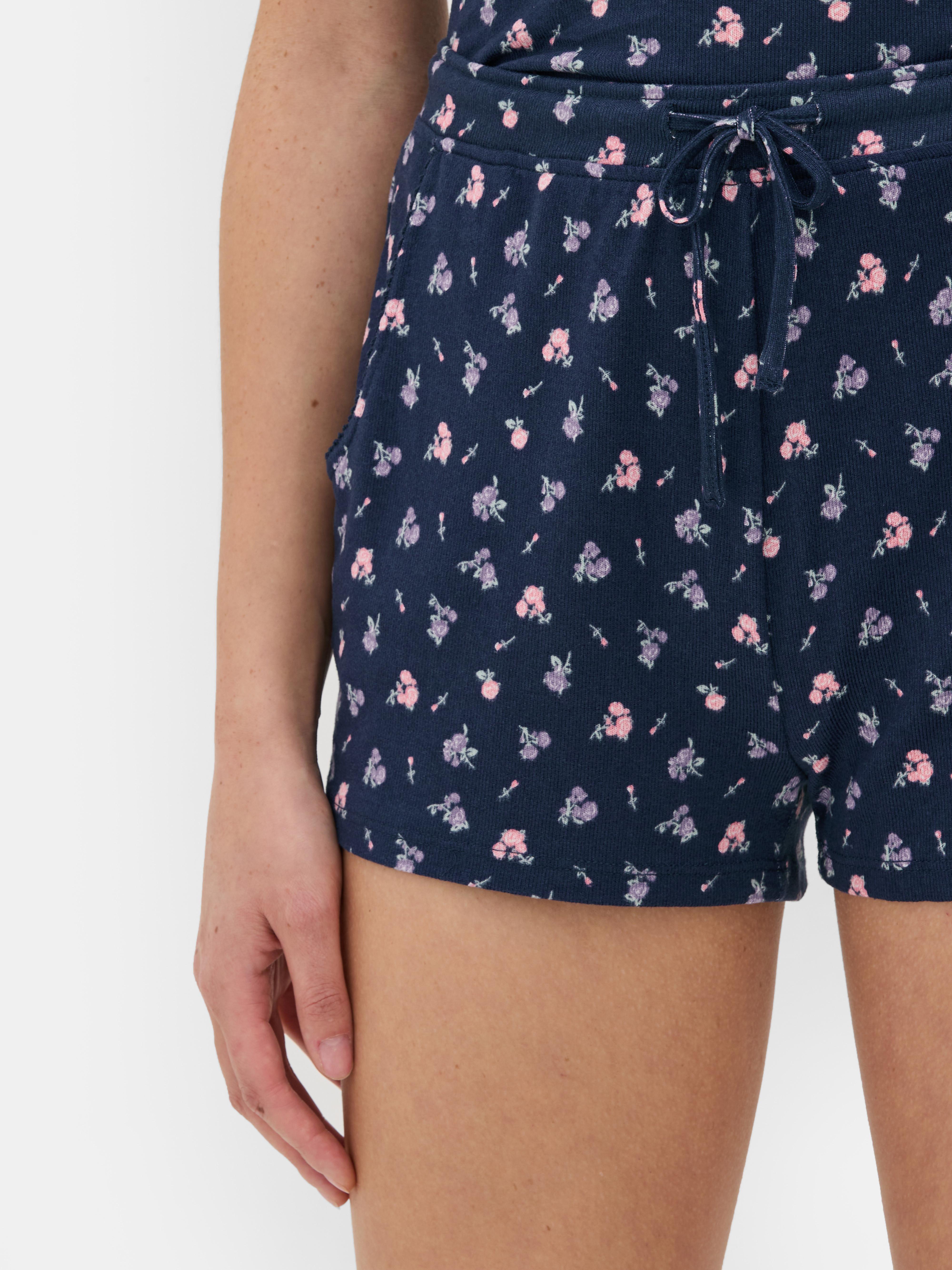 Pantaloni scurți de pijama tricotați cu flori. Pantaloni scurți de pijama cu model floral, șnur în talie și buzunare laterale.