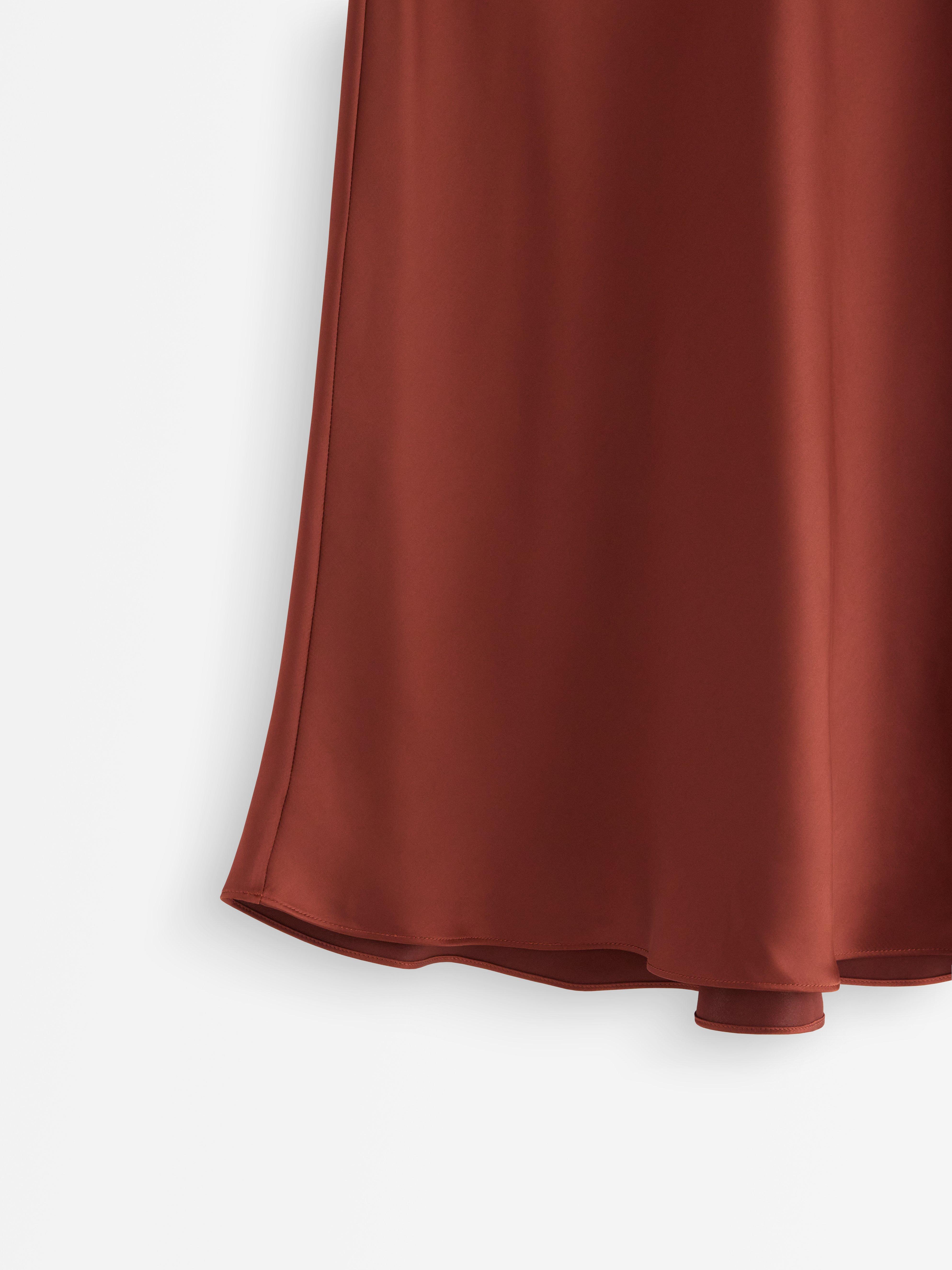 Falda midi de satén color rojo oscuro empolvado.