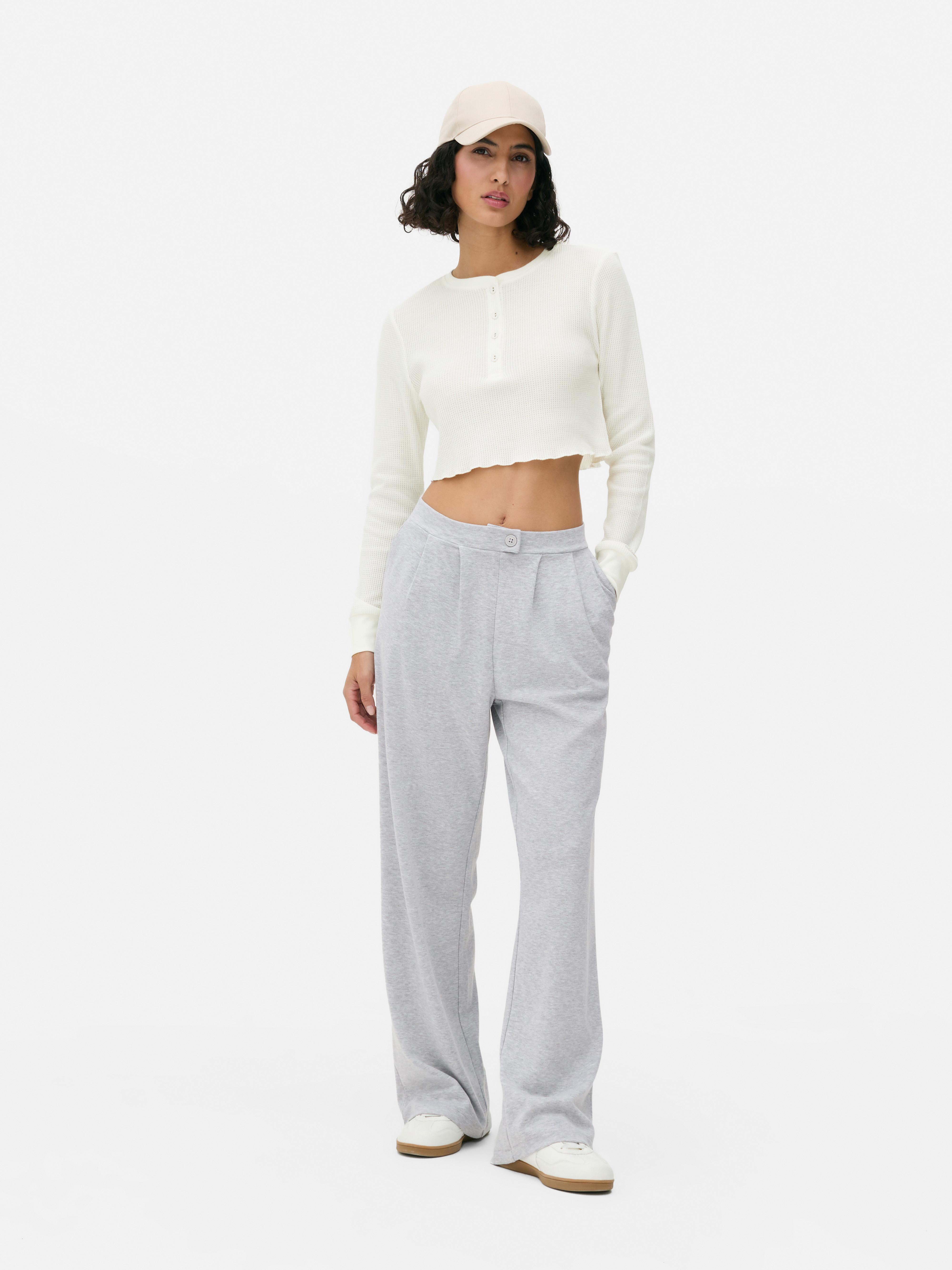 Pantaloni de trening din jerseu mulați. Acești pantaloni de trening au o fentă vizibilă cu nasturi și o siluetă elegantă.