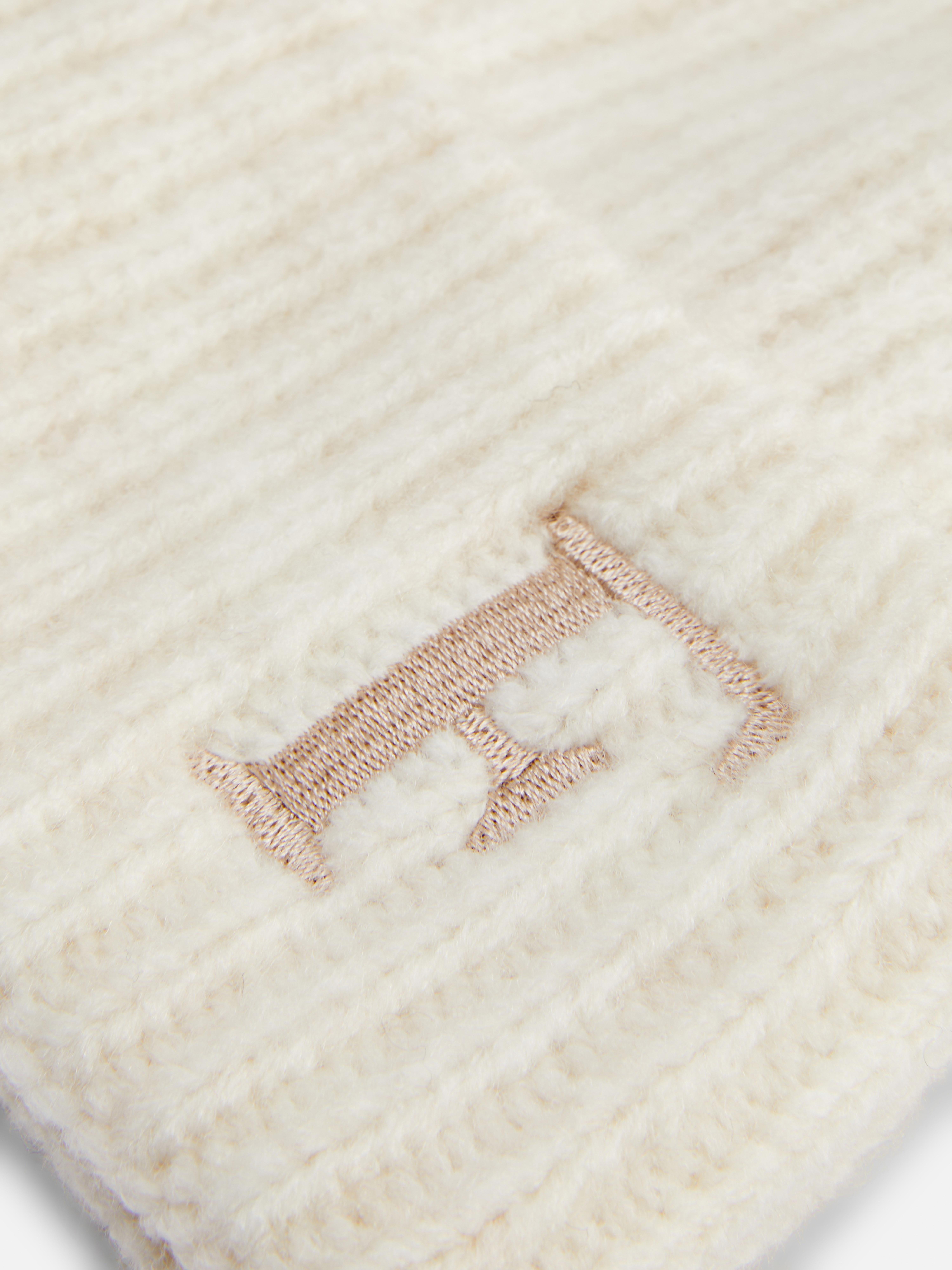 Mütze mit Bommel und gesticktem Anfangsbuchstaben. Die klassische Rippstrickmütze mit Bommel erhält durch die Stickerei eine persönliche Note.