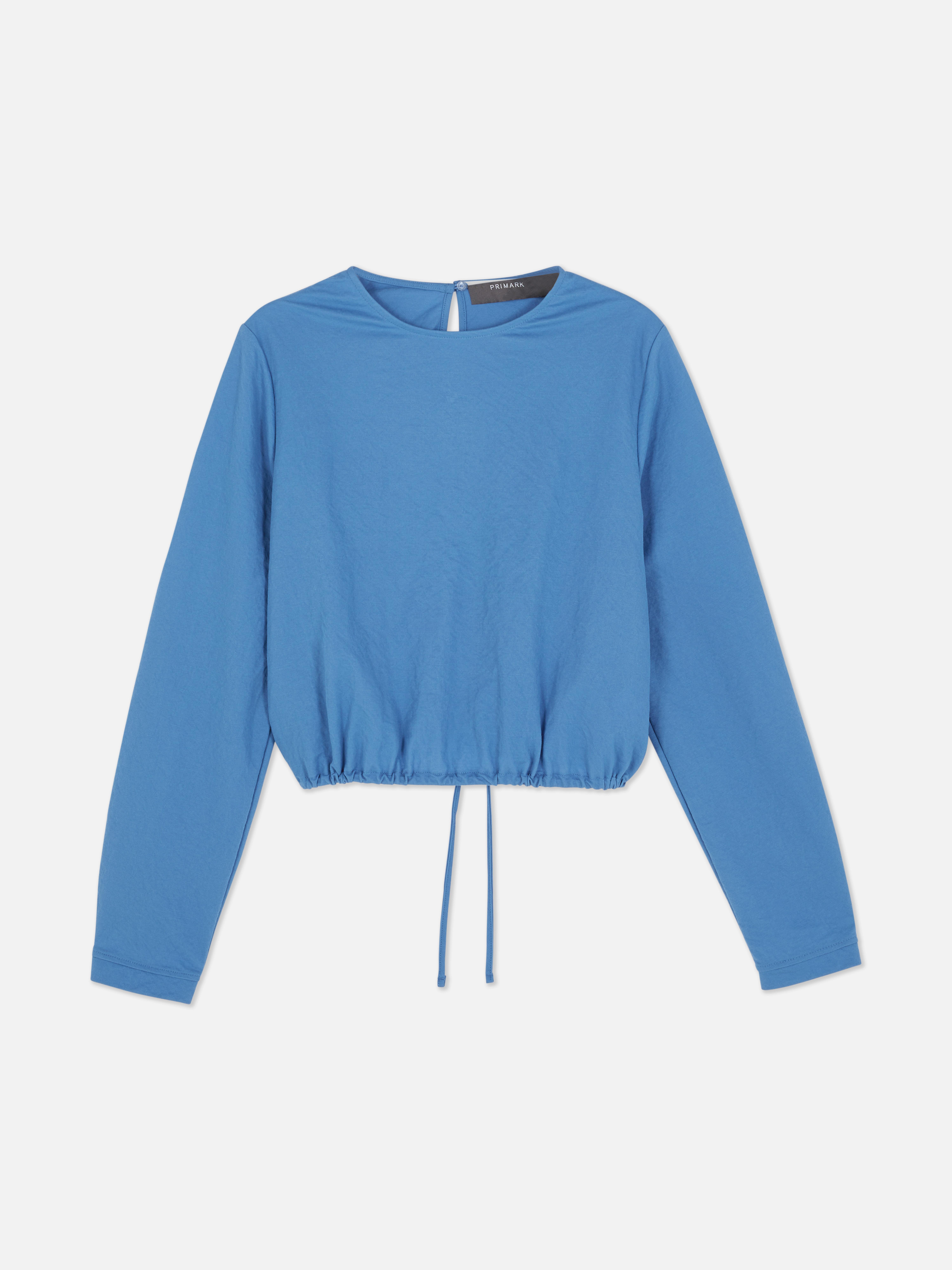 Bluză cu tiv elastic. Acest top are mâneci lungi și un tiv reglabil.