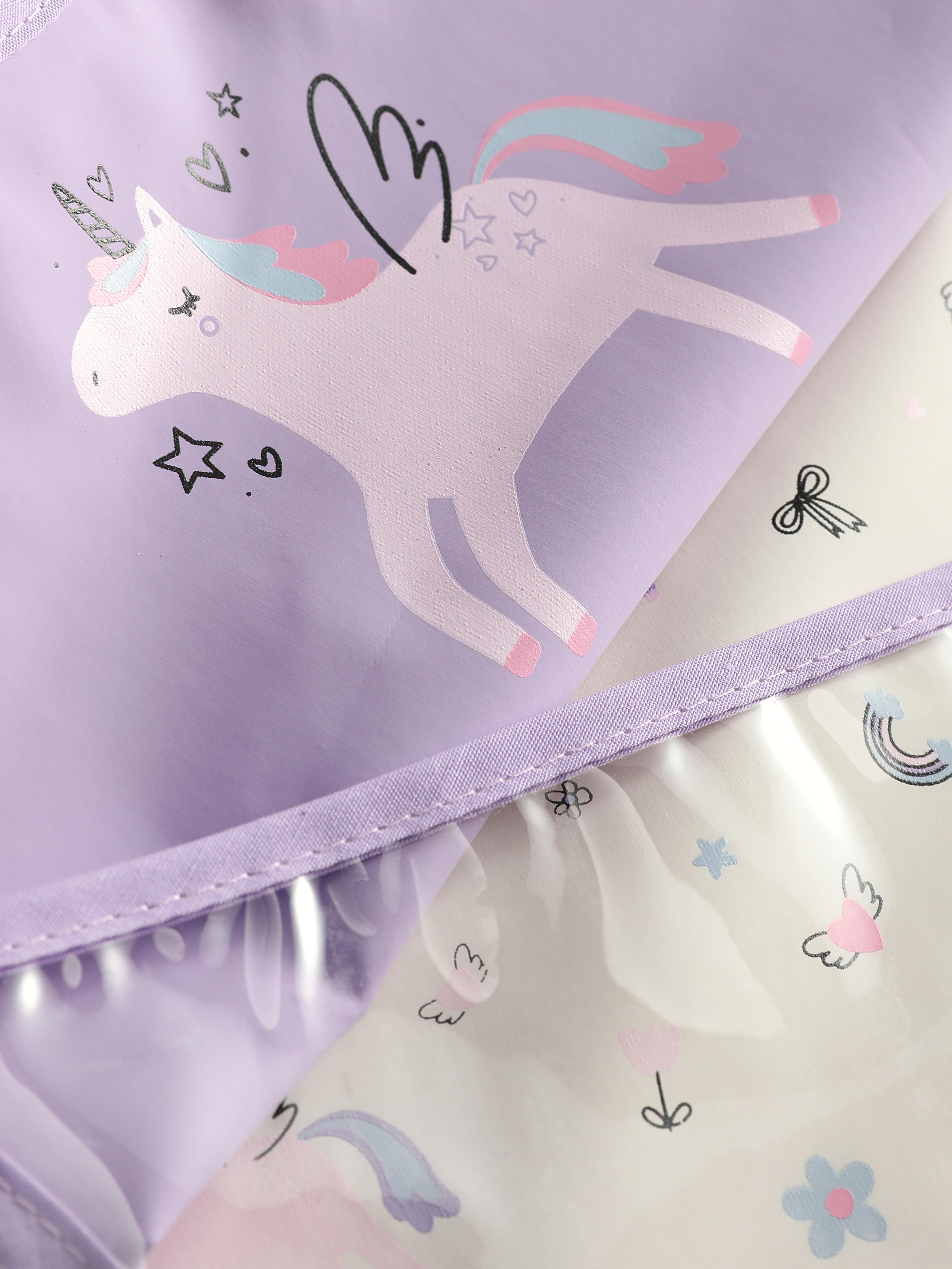 Bavete cu gât înfășurat și unicorn, set de 2. Aceste bavete pentru bebeluși au gât înfășurat cu închidere automată și buzunare cu sistem de închidere.