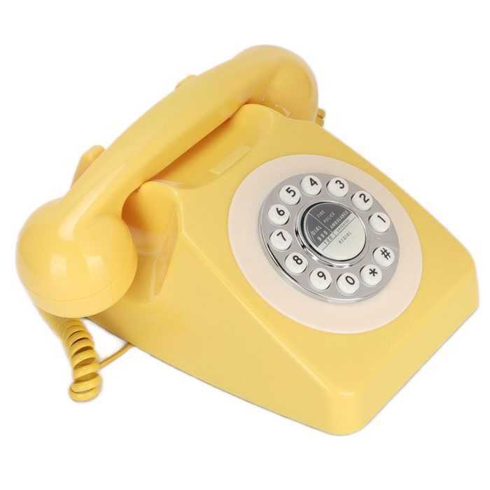 Teléfono fijo clásico retro con cable en color amarillo, estilo vintage, para telefonía doméstica y decoración de interiores.